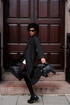 Stylish woman poses confidently in a trendy outfit outside a wooden door entryway in Aberdeen.