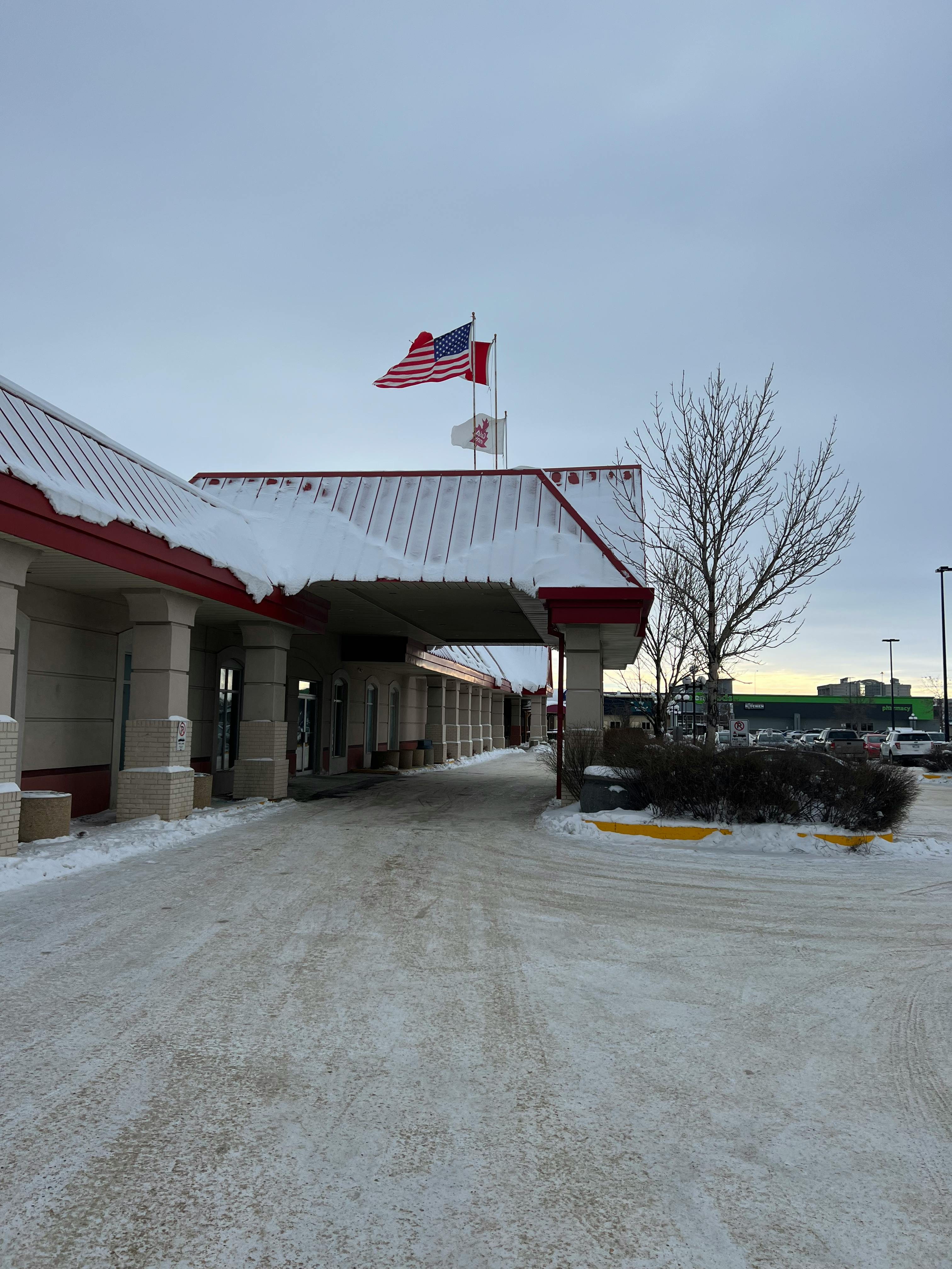 Gratis Snødekt inngang ved Pembina grensestasjon med amerikanske og kanadiske flagg. Arkivbilde