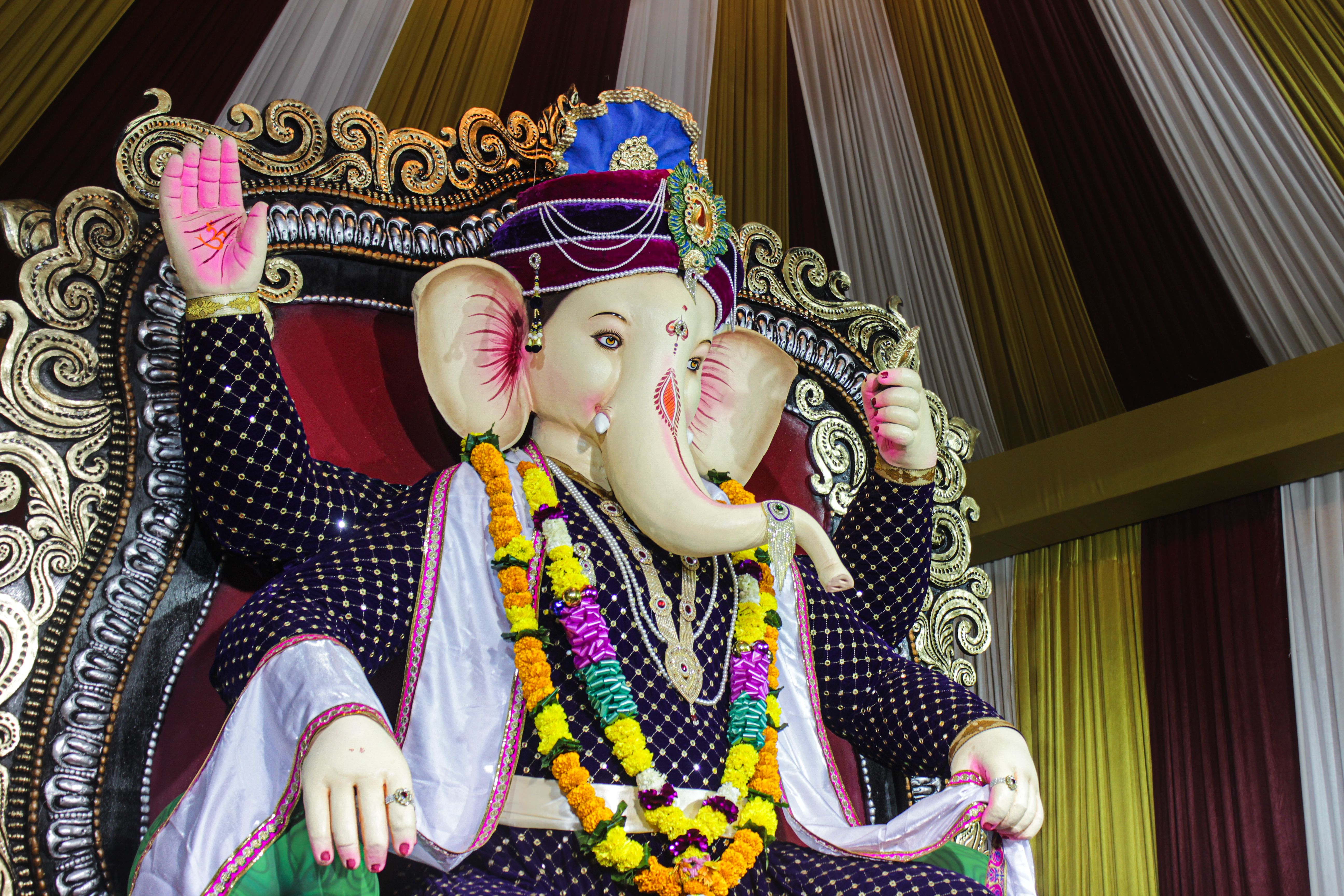 Colorful Ganesha statue adorned with flowers during Ganesh Chaturthi in Vyara, Gujarat, India.