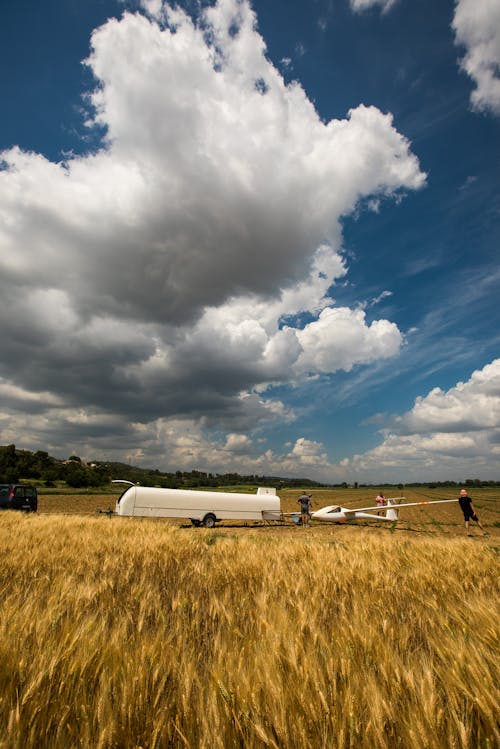 Free stock photo of clouds, glider on the field, outlanding