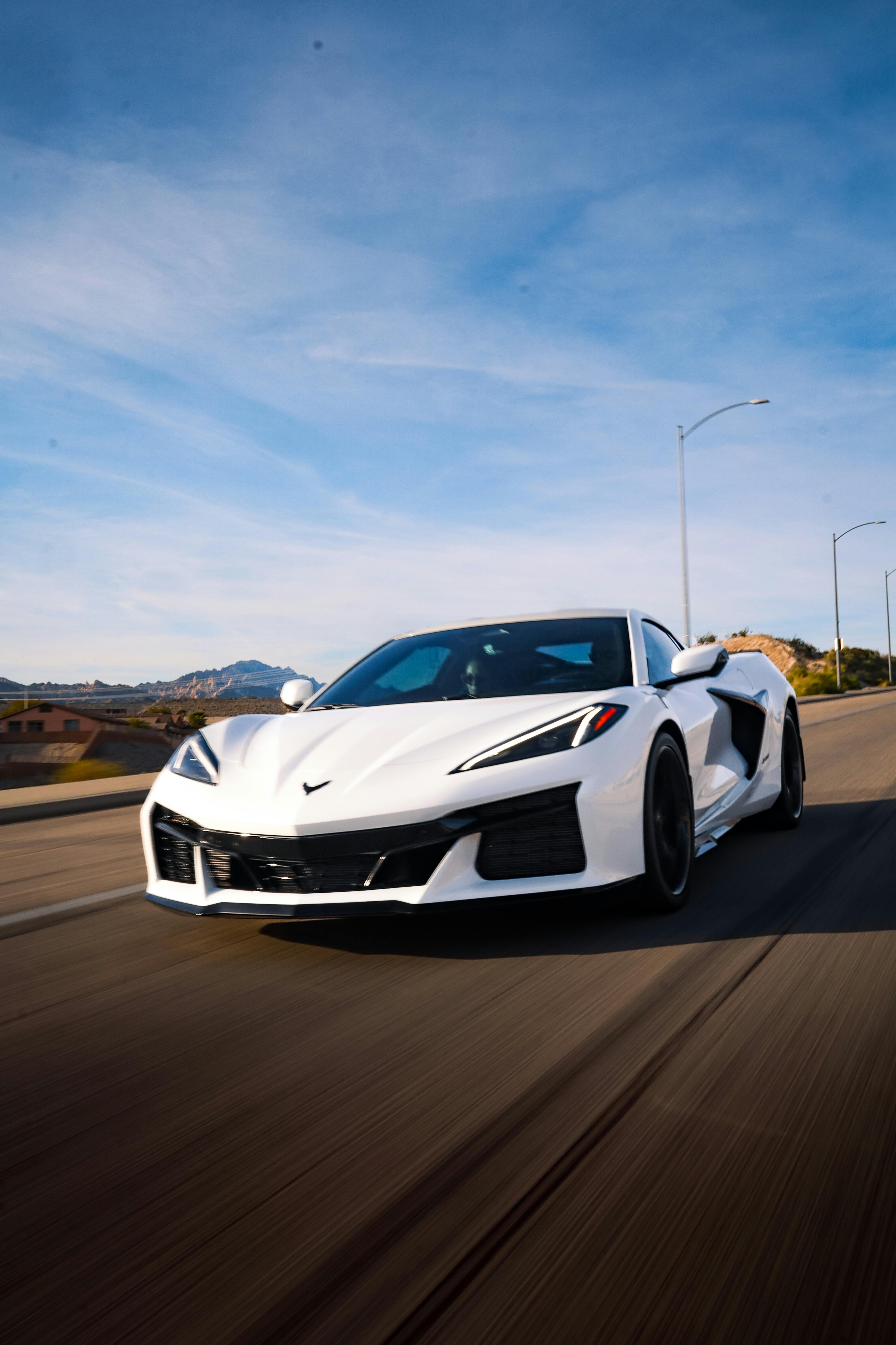 Gratis Hvid sportsvogn kører på en naturskøn motorvej i Laughlin, Nevada med bjerge i baggrunden. Lagerfoto