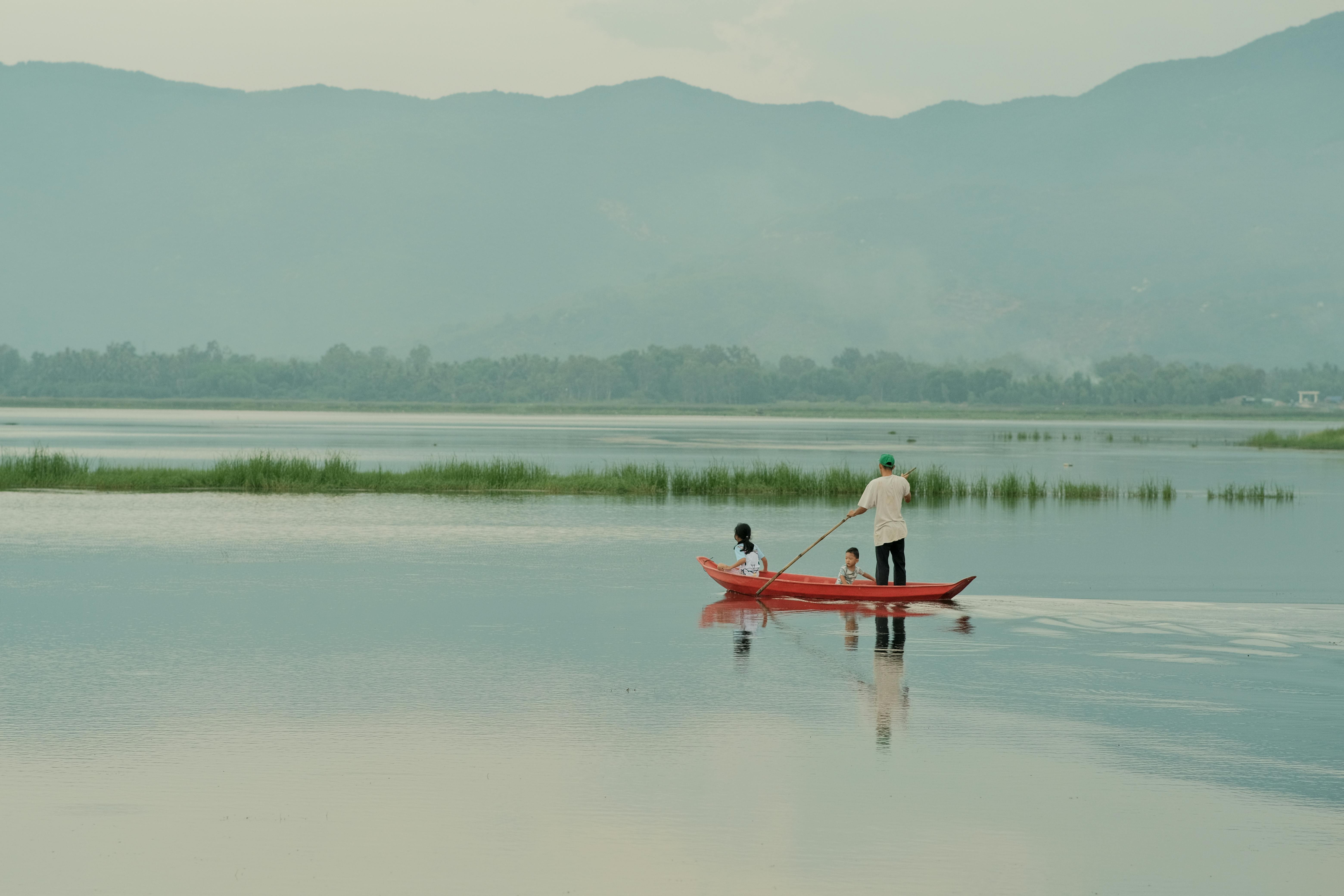 Gratis Et fredeligt landskab med en lille båd på en sø med bjerge i Vietnam. Lagerfoto