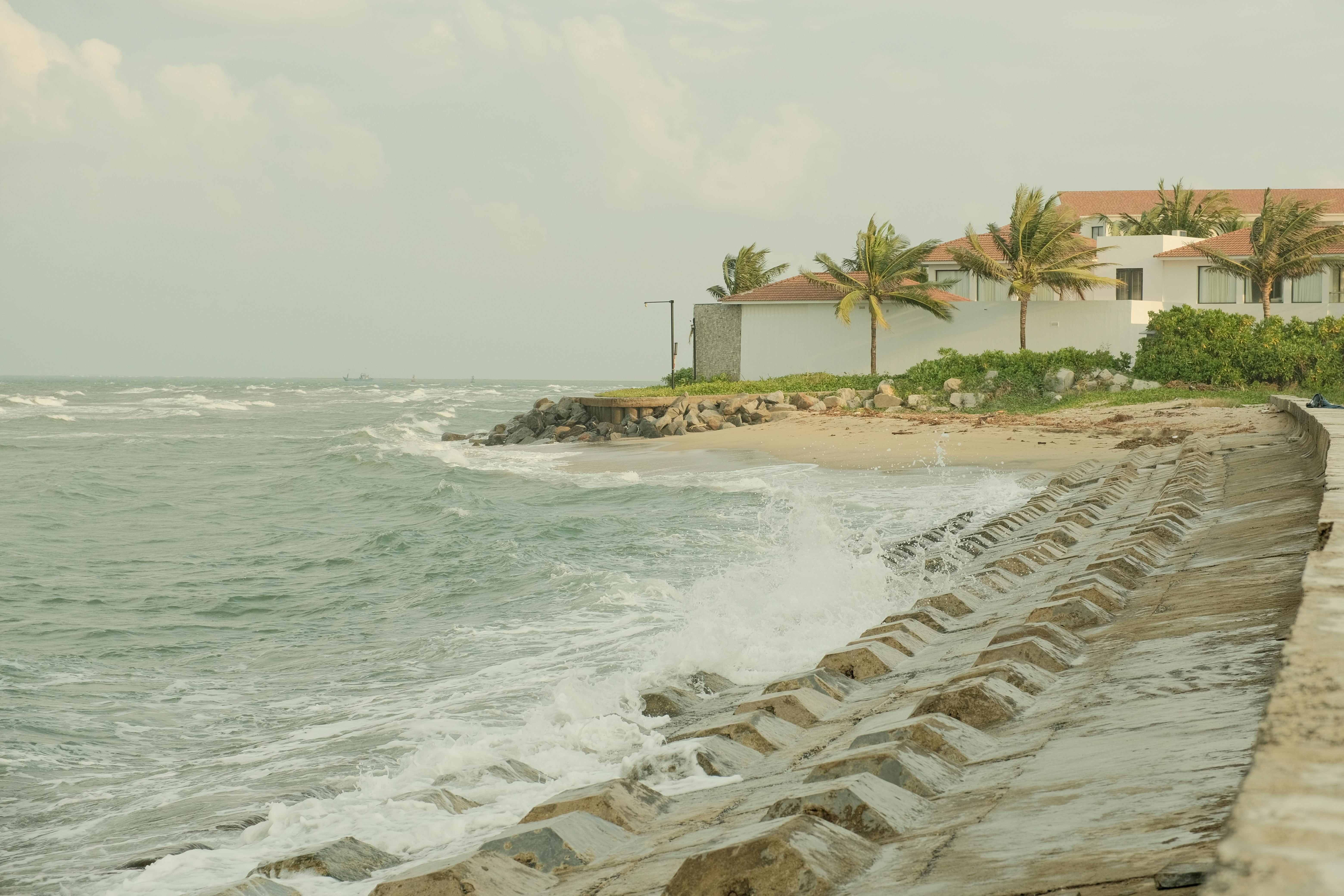 Beautiful coastal scene in Hội An, Vietnam showing waves crashing against the seawall.