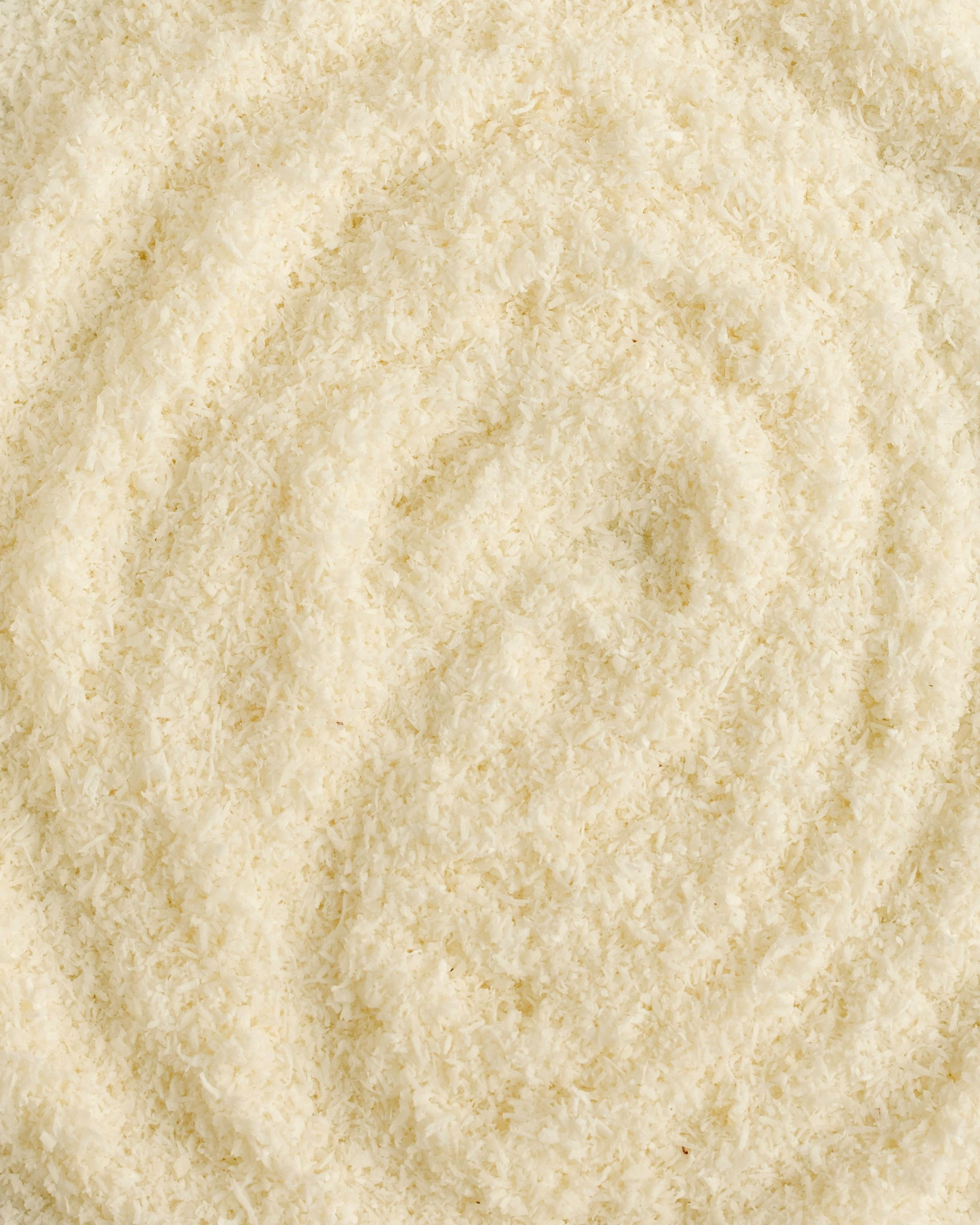 無料 繊維やファッションの背景に最適な、螺旋模様を形成するテクスチャ加工されたベージュのウール生地の詳細図。 写真素材