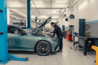 Mechanic Working on Luxury Car in Modern Garage