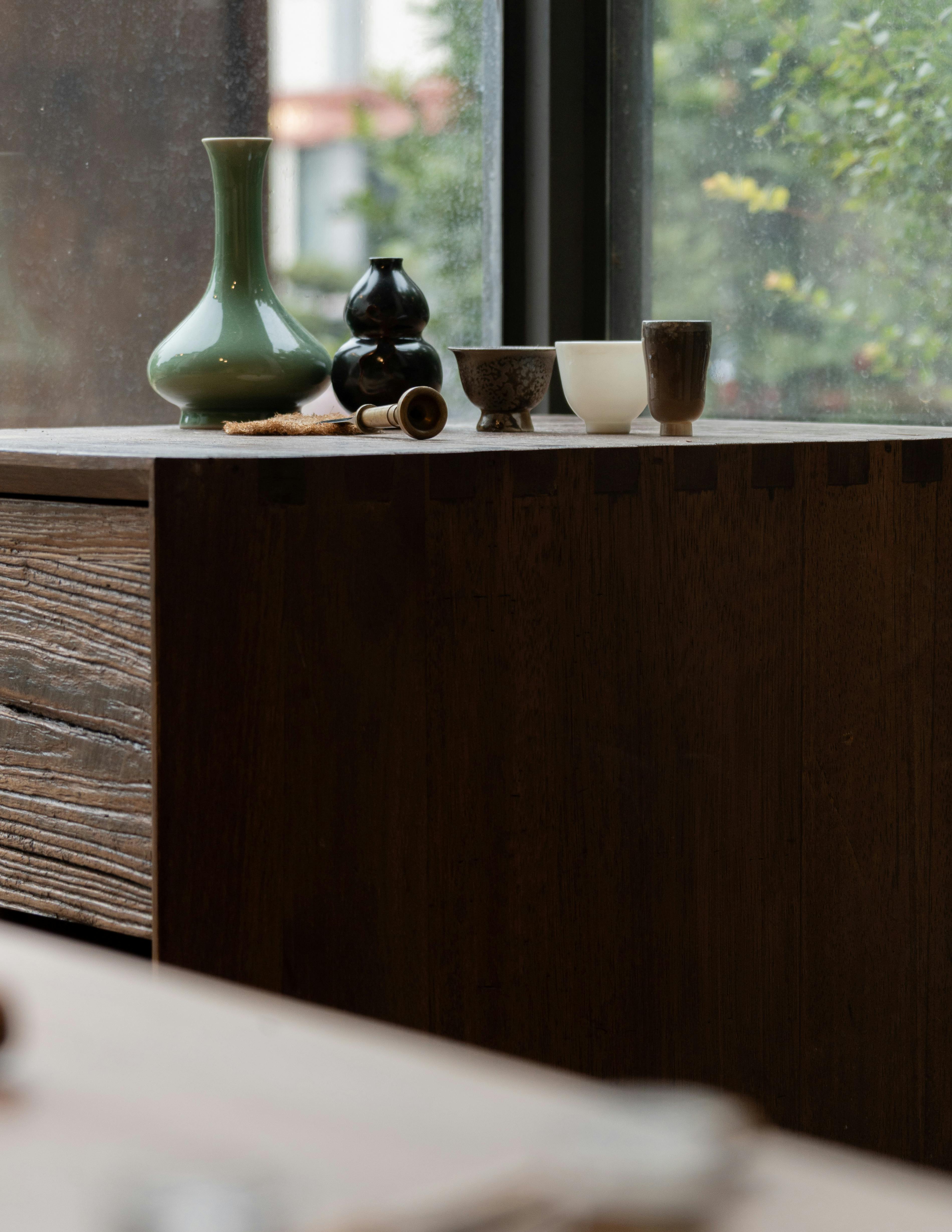 Gratis Et fredfullt stilleben innendørs med kunstferdige vaser og tekopper på en treflate. Arkivbilde