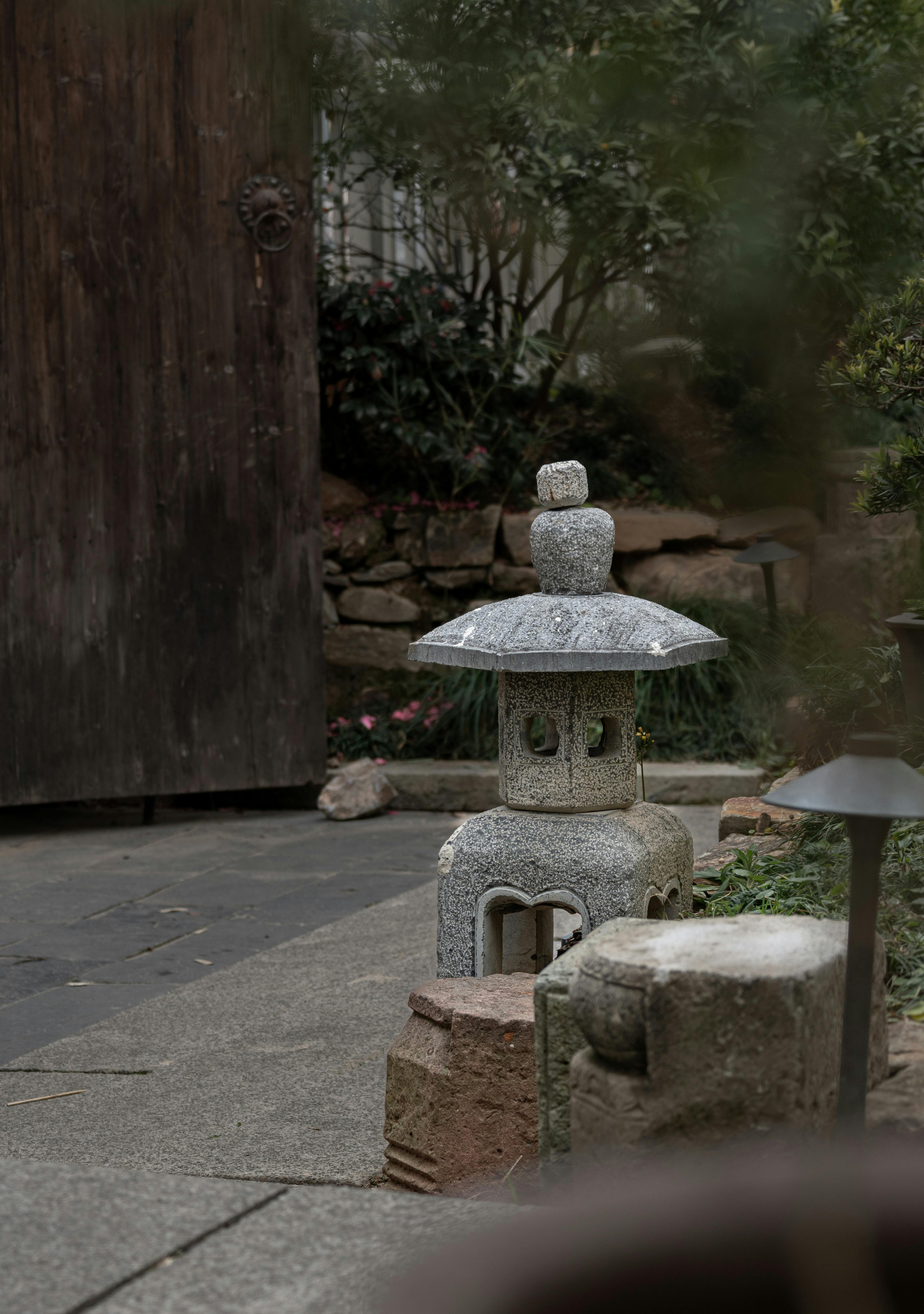 De franc Un tranquil jardí japonès amb un fanal de pedra ornamental enmig d'una vegetació exuberant. Foto d'estoc