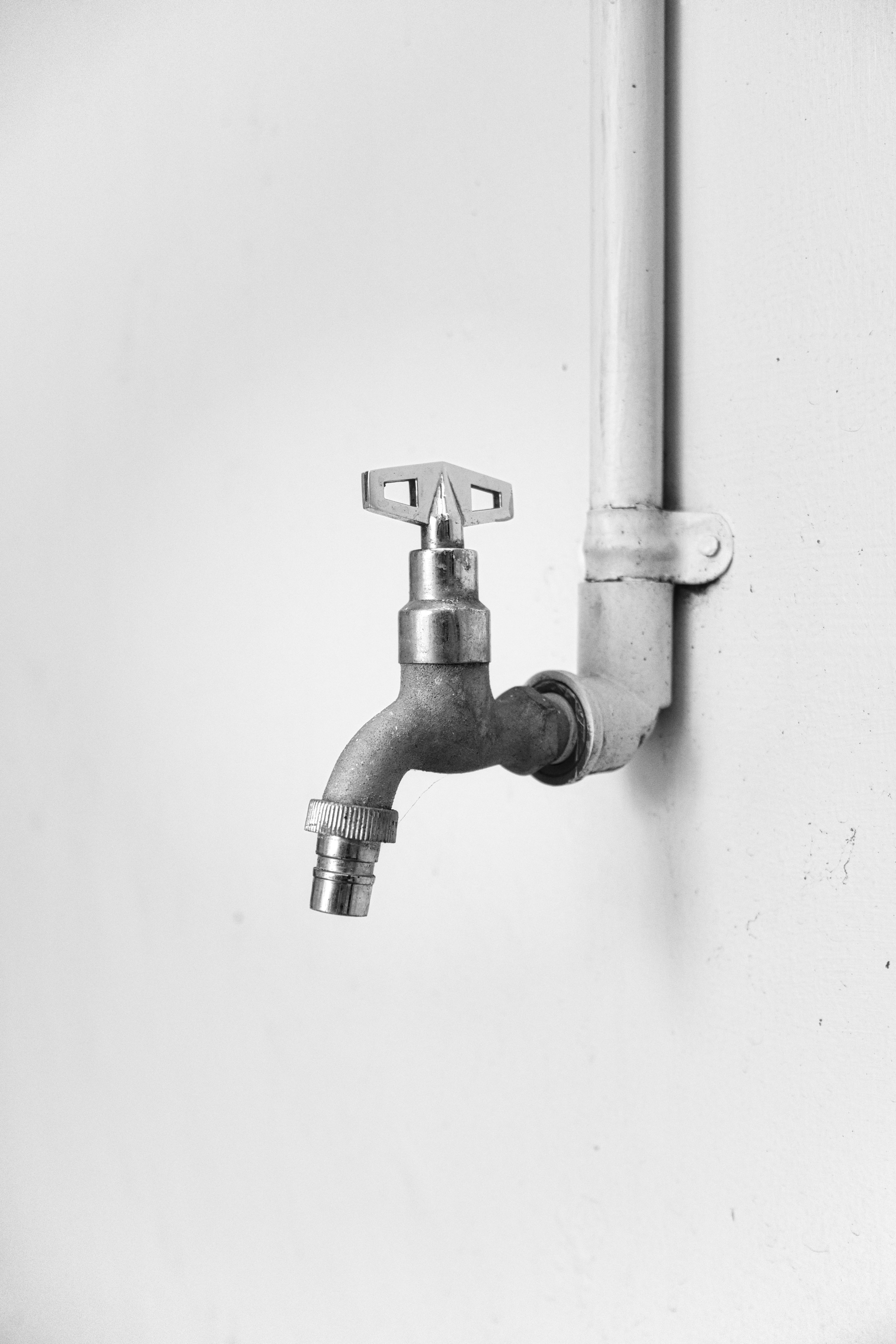 Gratis Et minimalistisk svart-hvitt-bilde av en metallkran på en vegg, som fremhever enkelhet og design. Arkivbilde