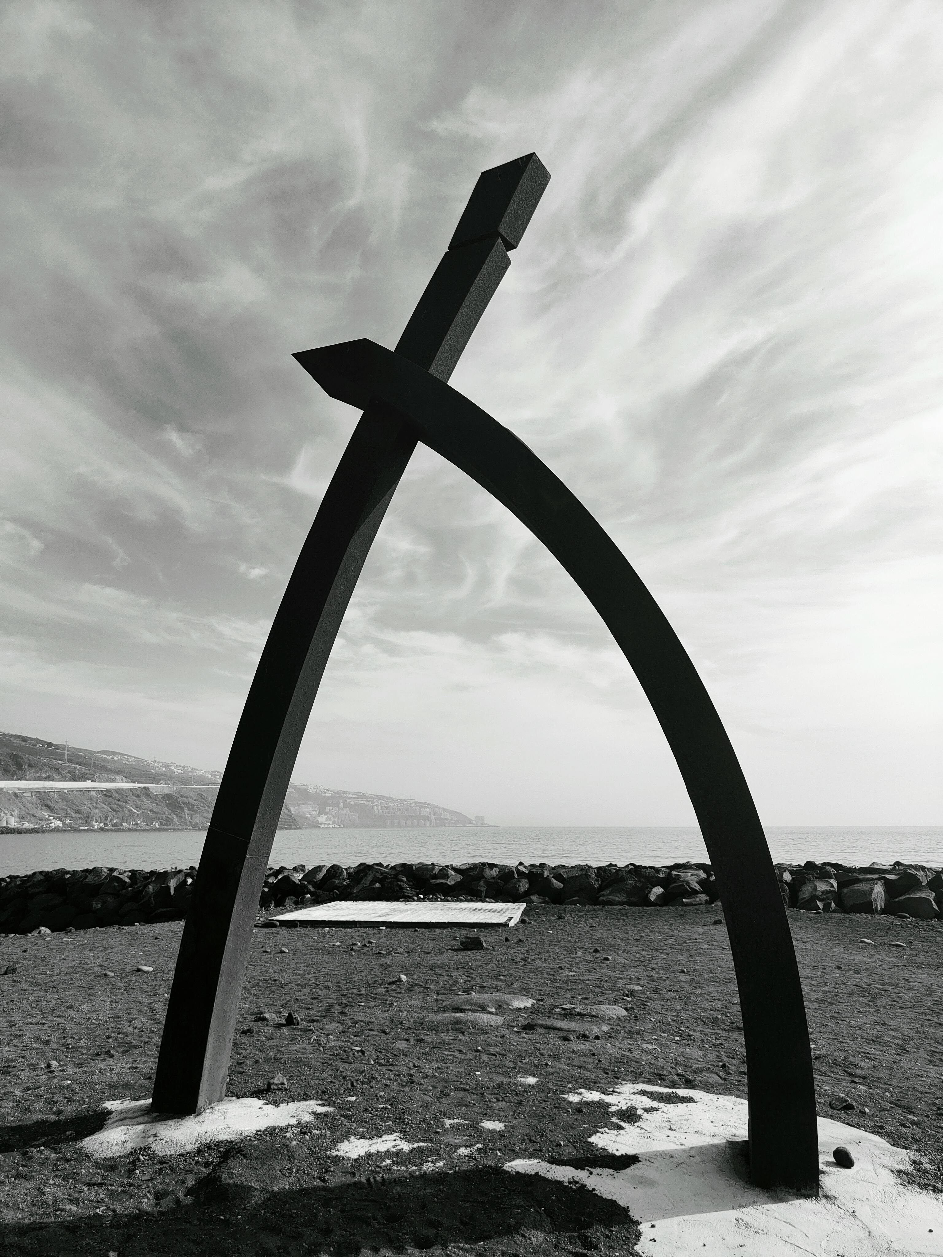 Free Black and white photo of a coastal abstract sculpture with dramatic cloud formations. Stock Photo