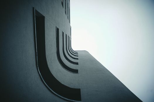 Futuristic building facade with curved elements viewed from below.