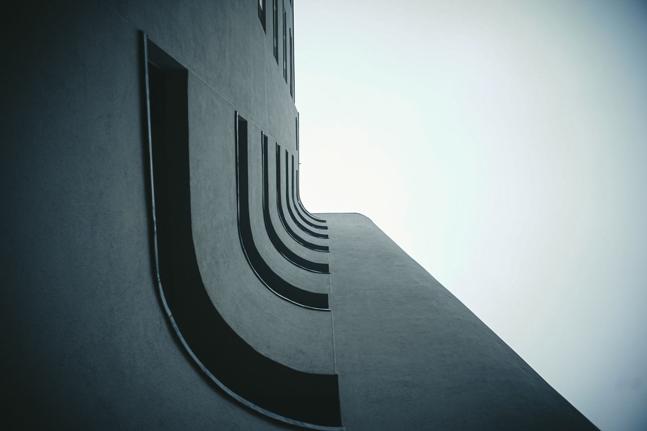 futuristic building facade with curved elements viewed from below