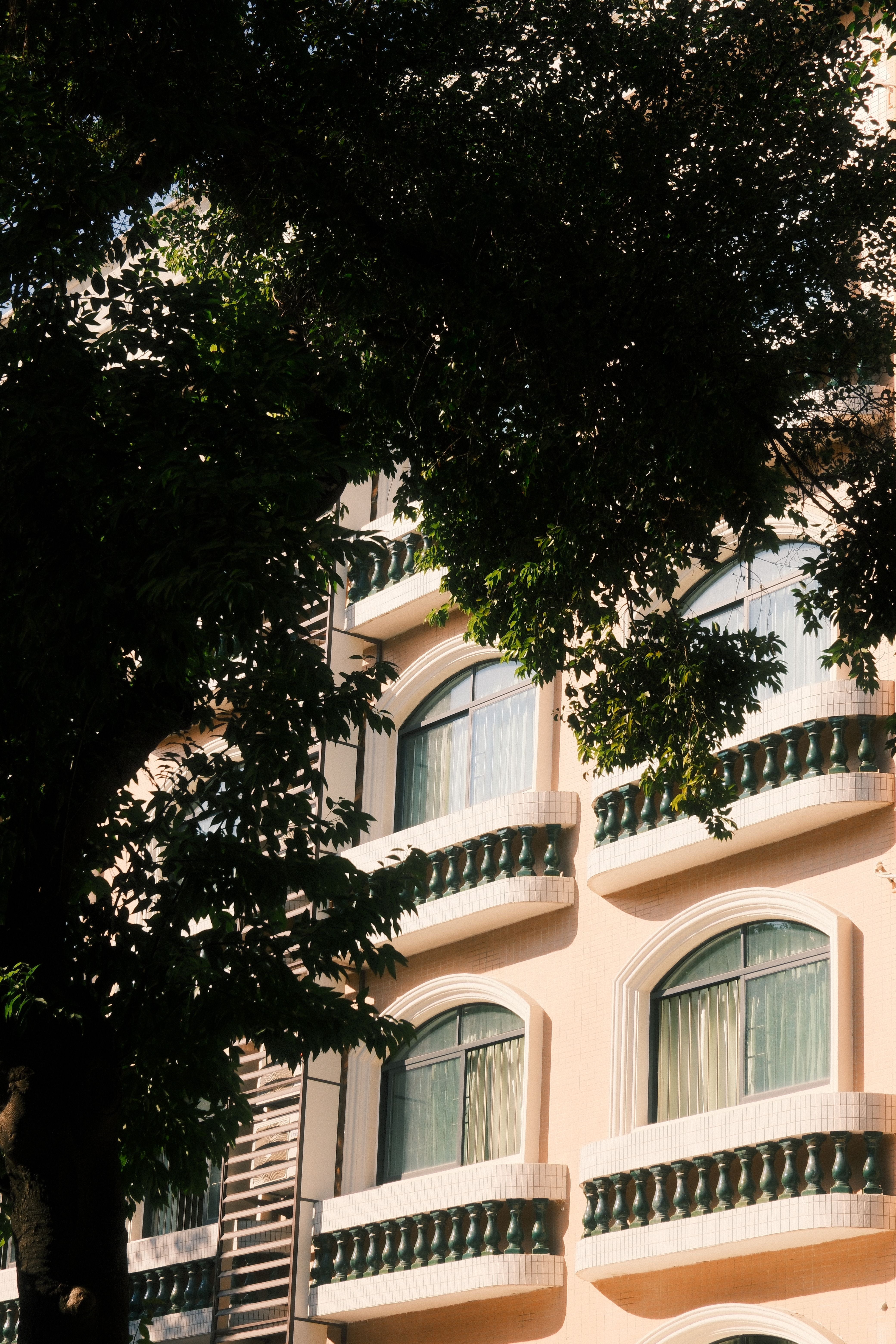 A beautiful building facade in Guangzhou, China, partially shaded by lush trees.