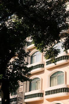 A beautiful building facade in Guangzhou, China, partially shaded by lush trees.