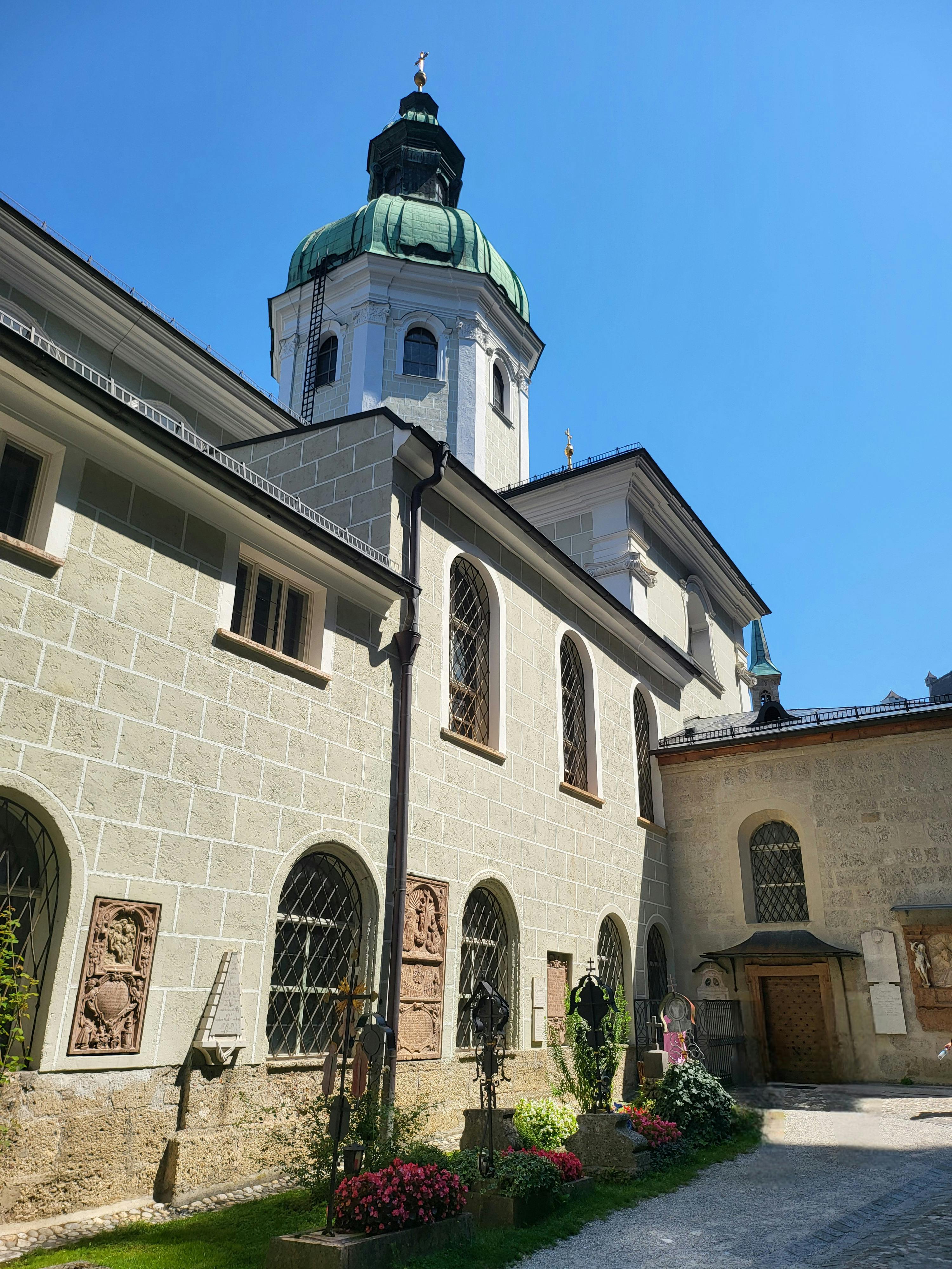 Gratis Pemandangan menawan halaman Katedral Salzburg di bawah langit biru cerah. Foto Stok
