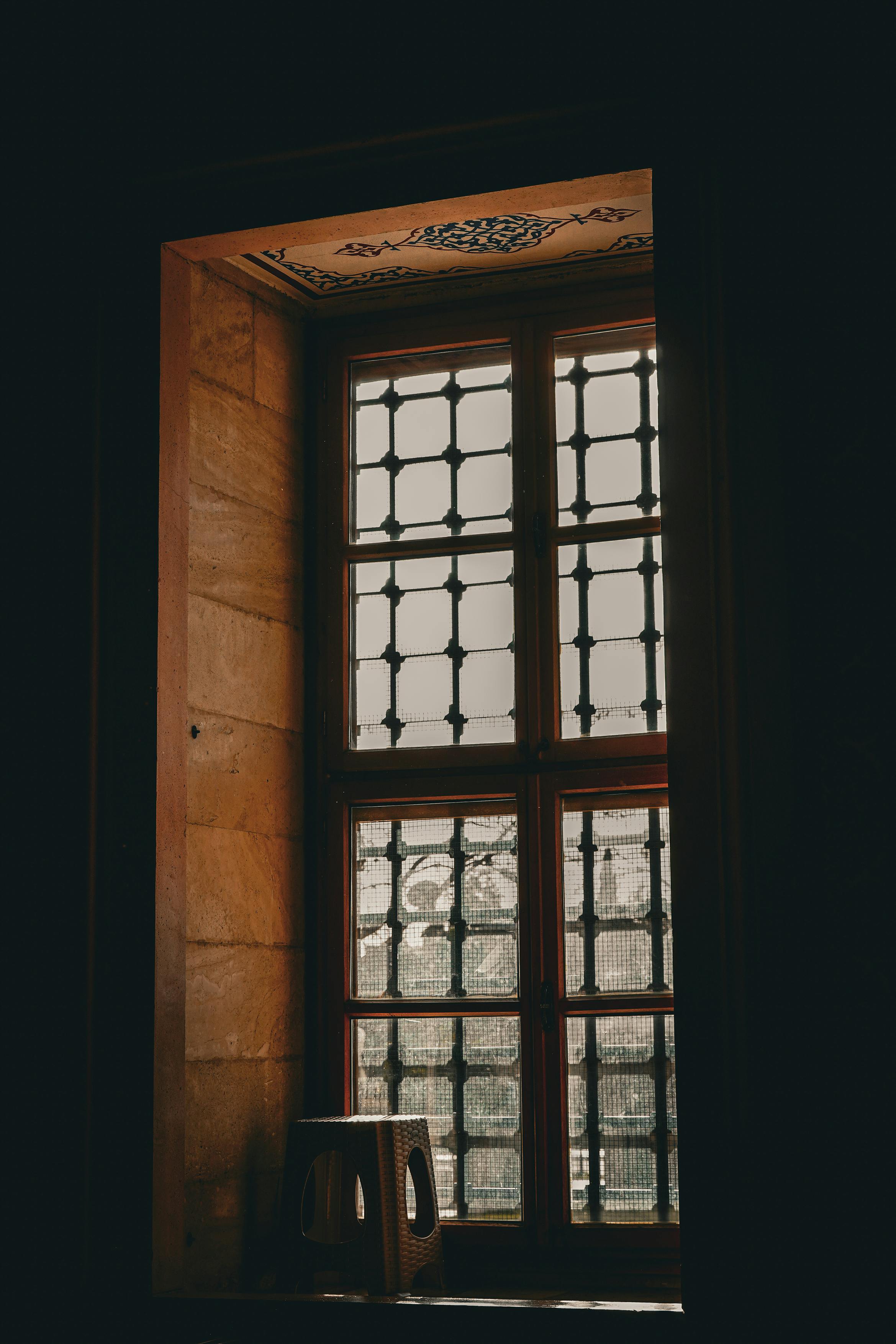 grátis Uma janela de madeira com um design belíssimo em Adana, Turquia, com uma treliça intrincada que permite a entrada de luz natural. Foto profissional