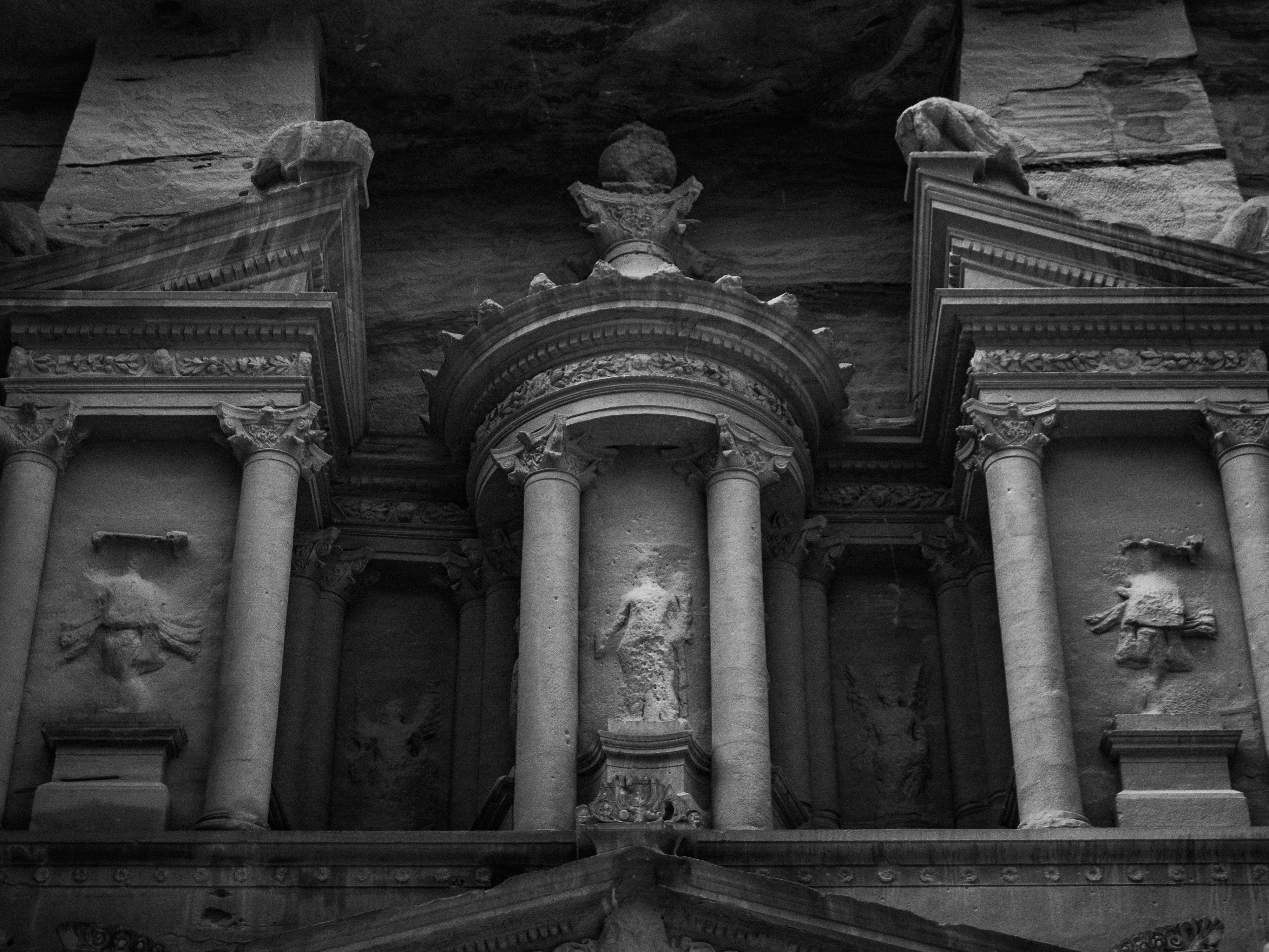 бесплатная Эффектная черно-белая фотография фасада сокровищницы Аль-Хазне в Петре, демонстрирующая замысловатую набатейскую архитектуру. Стоковое фото