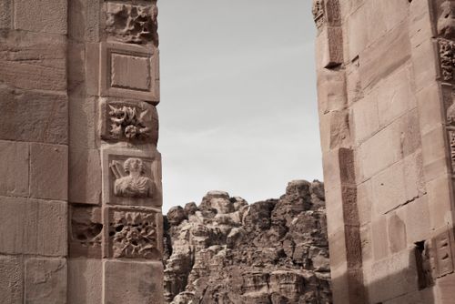 Free Detailed view of Petra's ancient ruins with intricate stone carvings against rocky backdrop in Wadi Musa, Jordan. Stock Photo