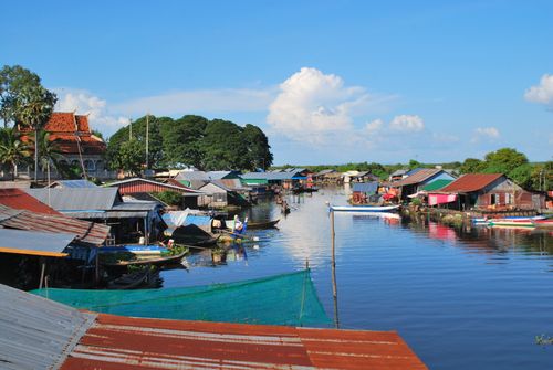 Free Picturesque floating village scene with vibrant houses by a river under a clear blue sky. Stock Photo