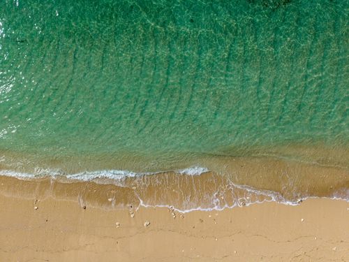 Free Breathtaking aerial view of emerald waters and sandy beach in Bali, Indonesia. Stock Photo
