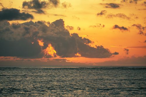 Free Captivating Bali sunset with dramatic clouds over the ocean, perfect for travel-themed imagery. Stock Photo