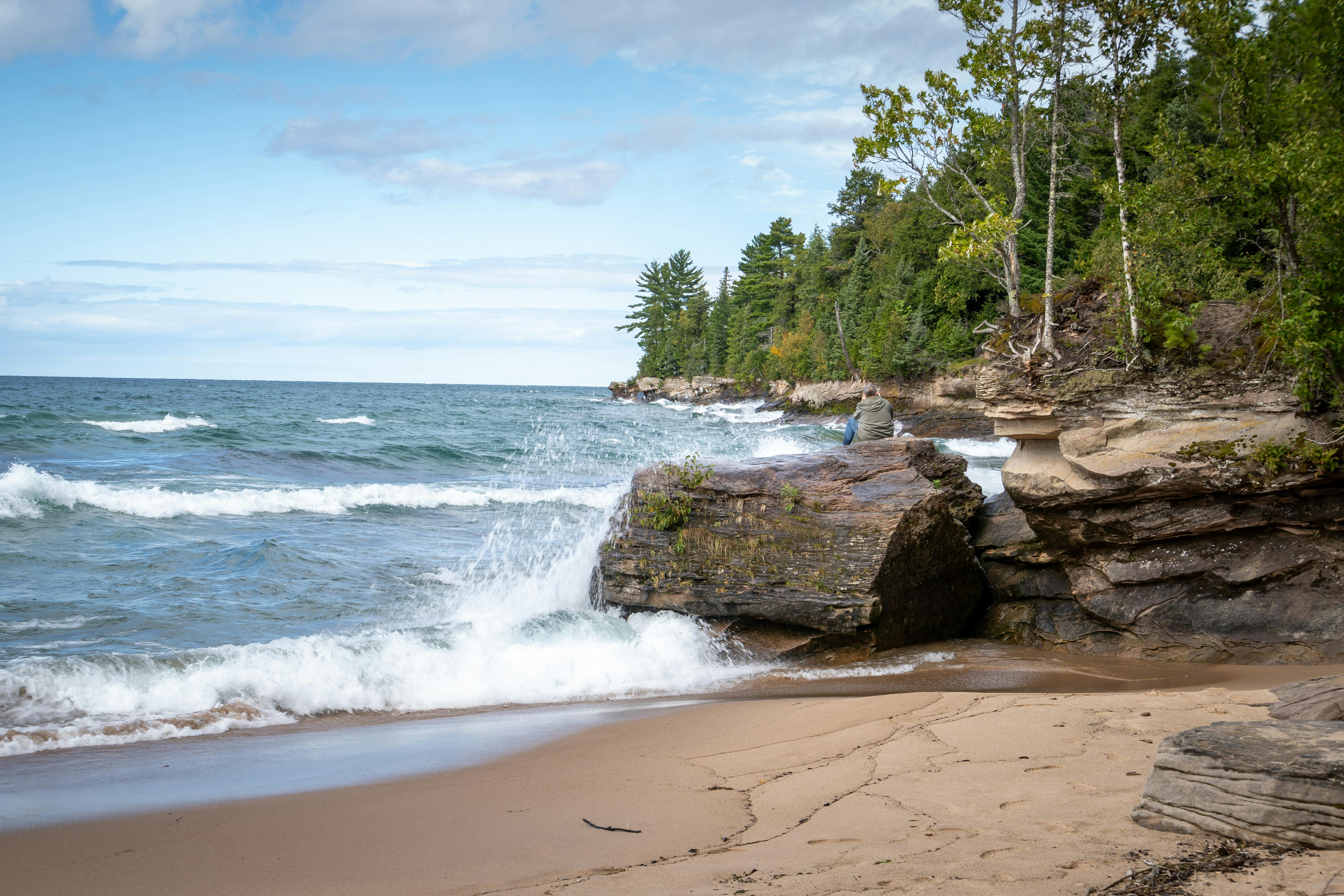 Dramatic waves crash against the rocky coastline of Lake Superior, capturing Michigan