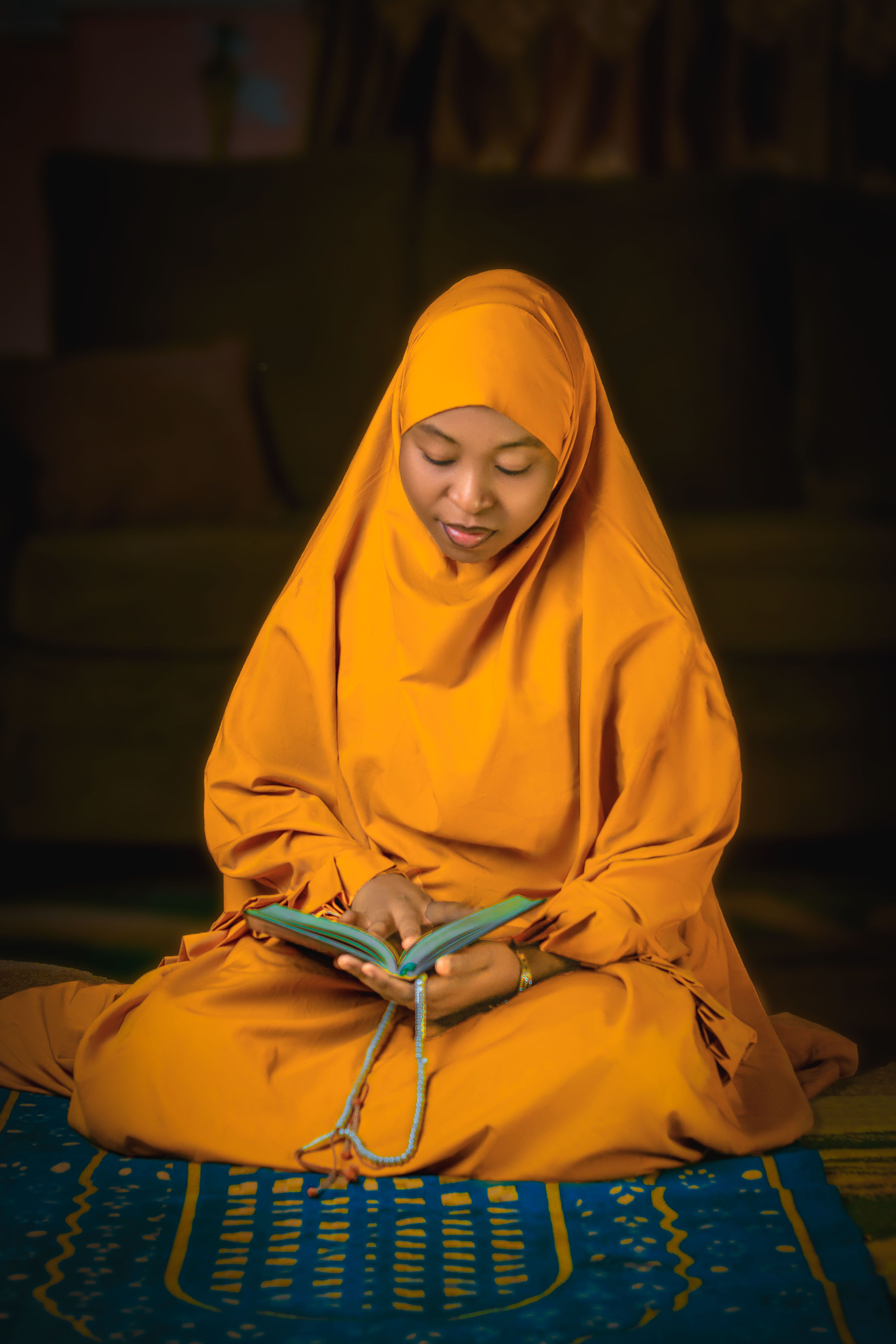 Young woman in hijab reading religious text indoors · Free Stock Photo