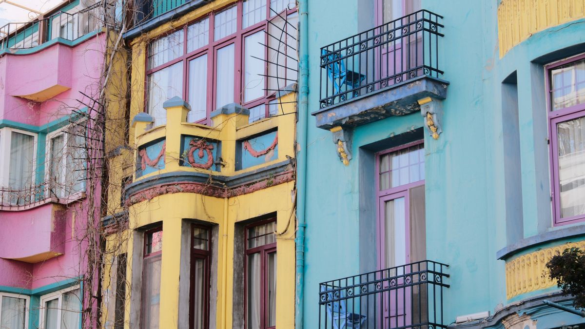Vibrant city scene with colorful apartment facades of pink, yellow, and blue.