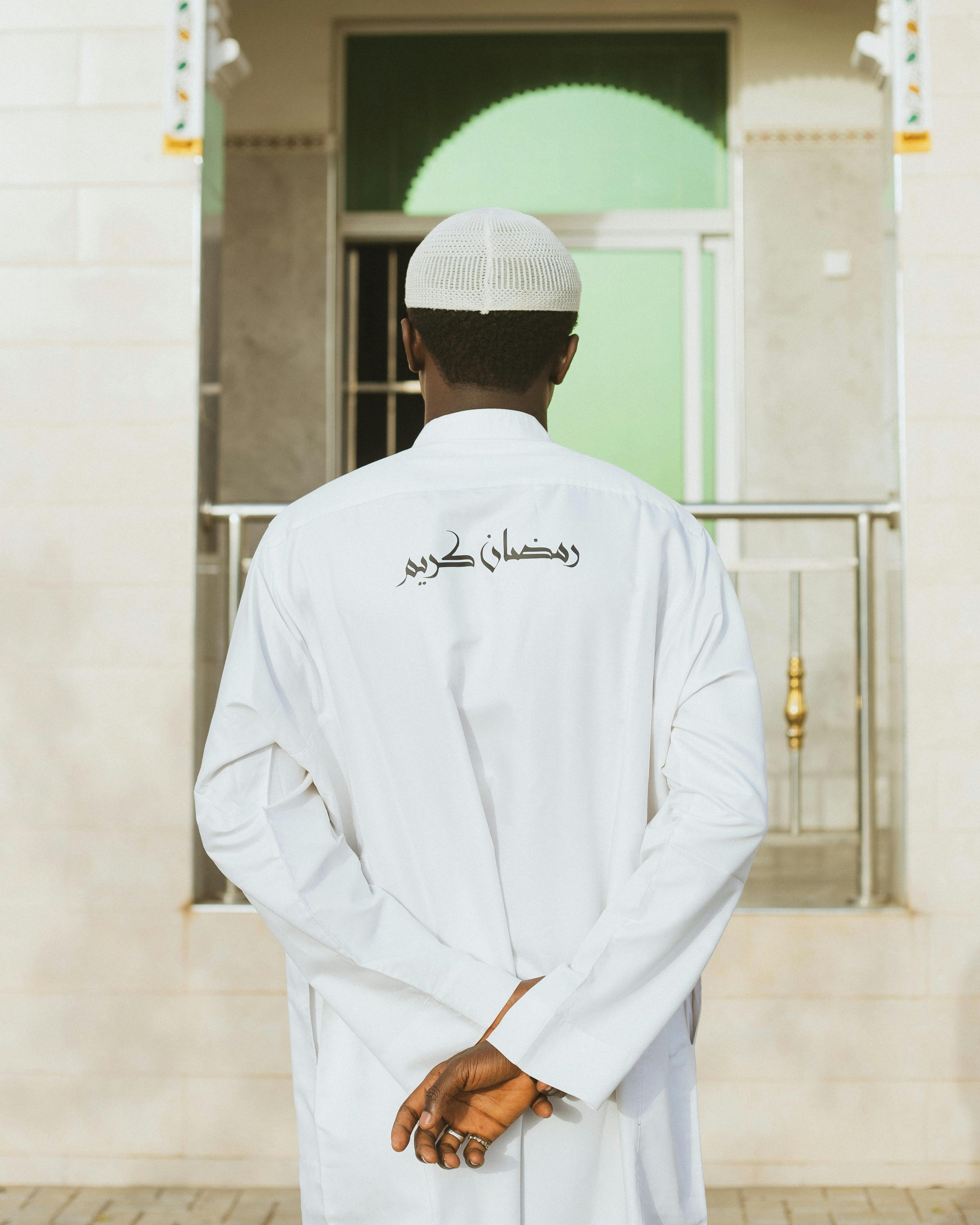 A young man in traditional attire with "Ramadan Kareem" written on his back in Kano, Nigeria.