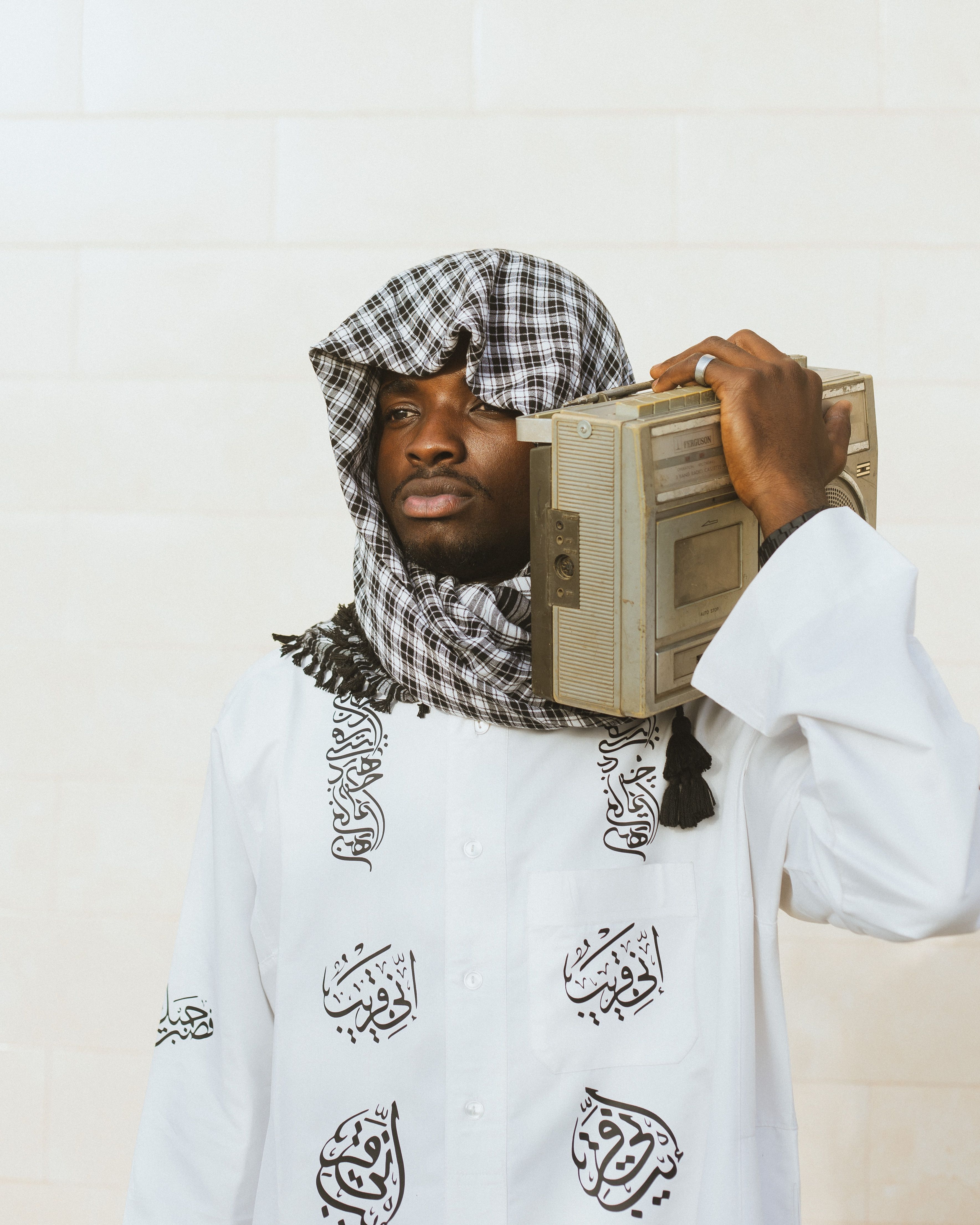 Nigerian man in traditional attire holding a vintage radio. Captured in Kano, Nigeria.