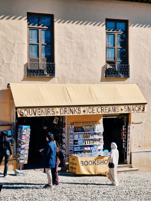 Free Cozy souvenir shop in Granada offering drinks, snacks, and books. Stock Photo