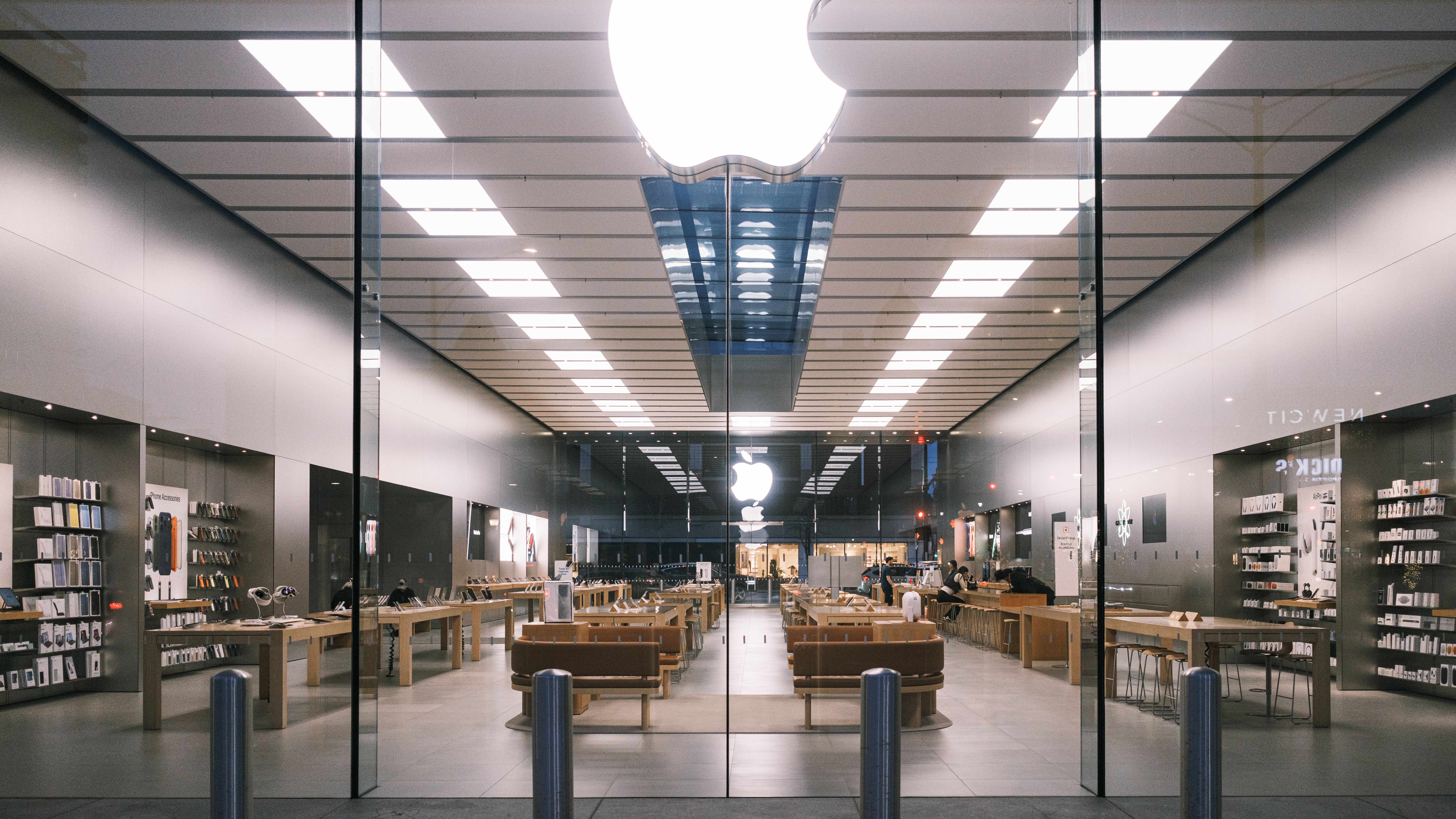 Modern technology retail store interior with product tables and digital displays.