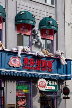 A vibrant store facade in Harbin, China, adorned with playful stuffed animals and colorful signage.
