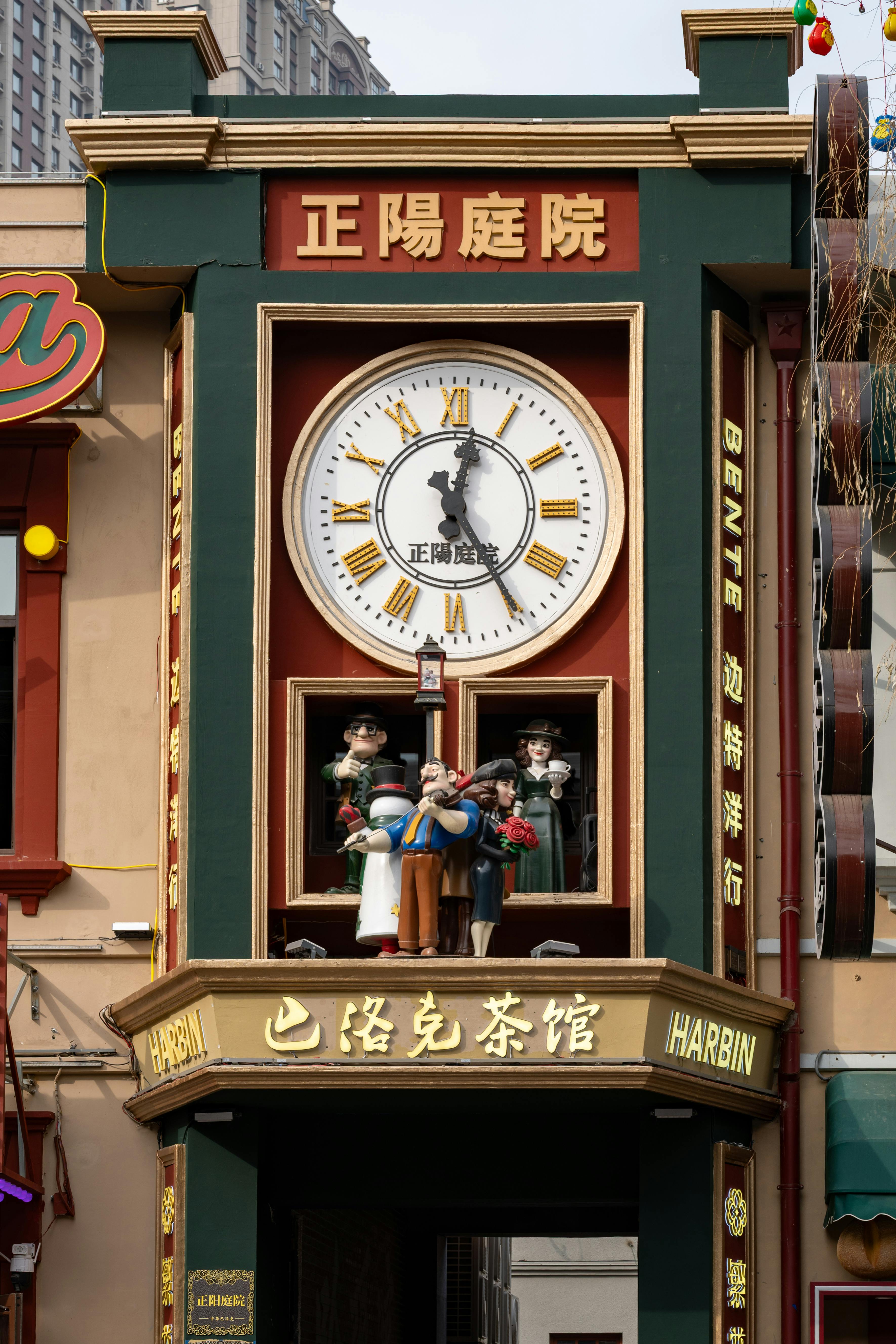 無料 ハルビンの活気ある中央街にある、文化的な人物を展示するユニークな装飾時計塔。 写真素材