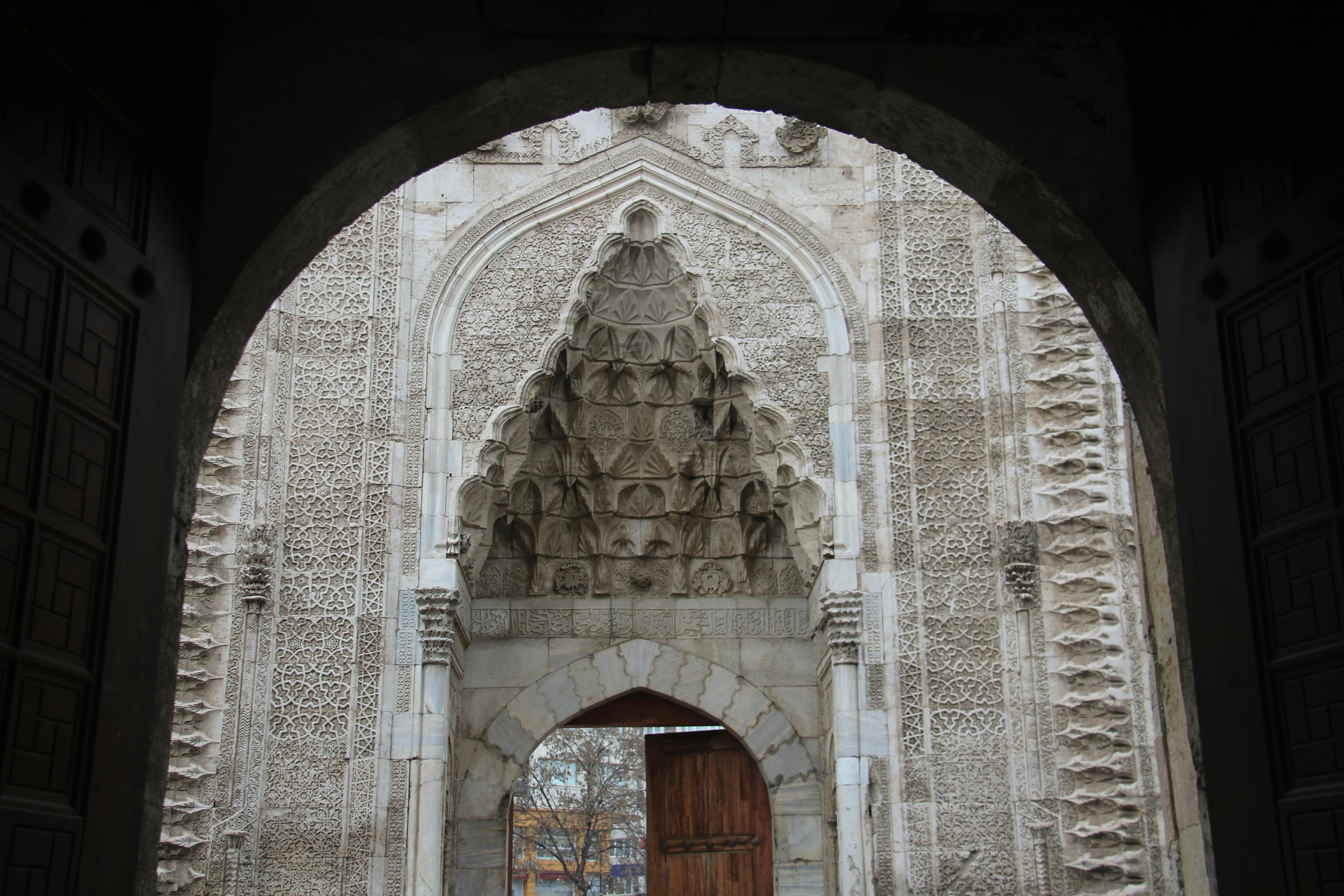 Gratis Tampilan detail dari sebuah gapura batu dengan ukiran rumit di bagian luar bangunan bersejarah. Foto Stok