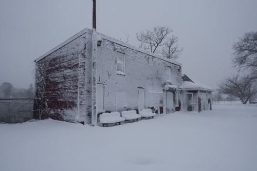 Free A deserted building covered in snow, conveying a serene winter landscape. Stock Photo