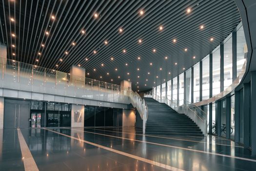 Elegant corporate hall featuring a curved staircase and sleek interior design.