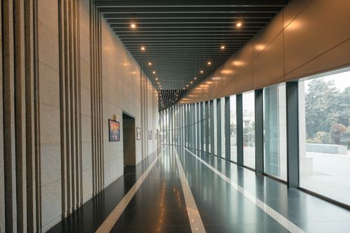 Free A sleek and modern interior corridor with large windows and sleek lines, suggesting luxury and corporate elegance. Stock Photo