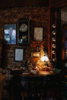 Cozy vintage home office with brick walls, warm lighting, and a classic clock.