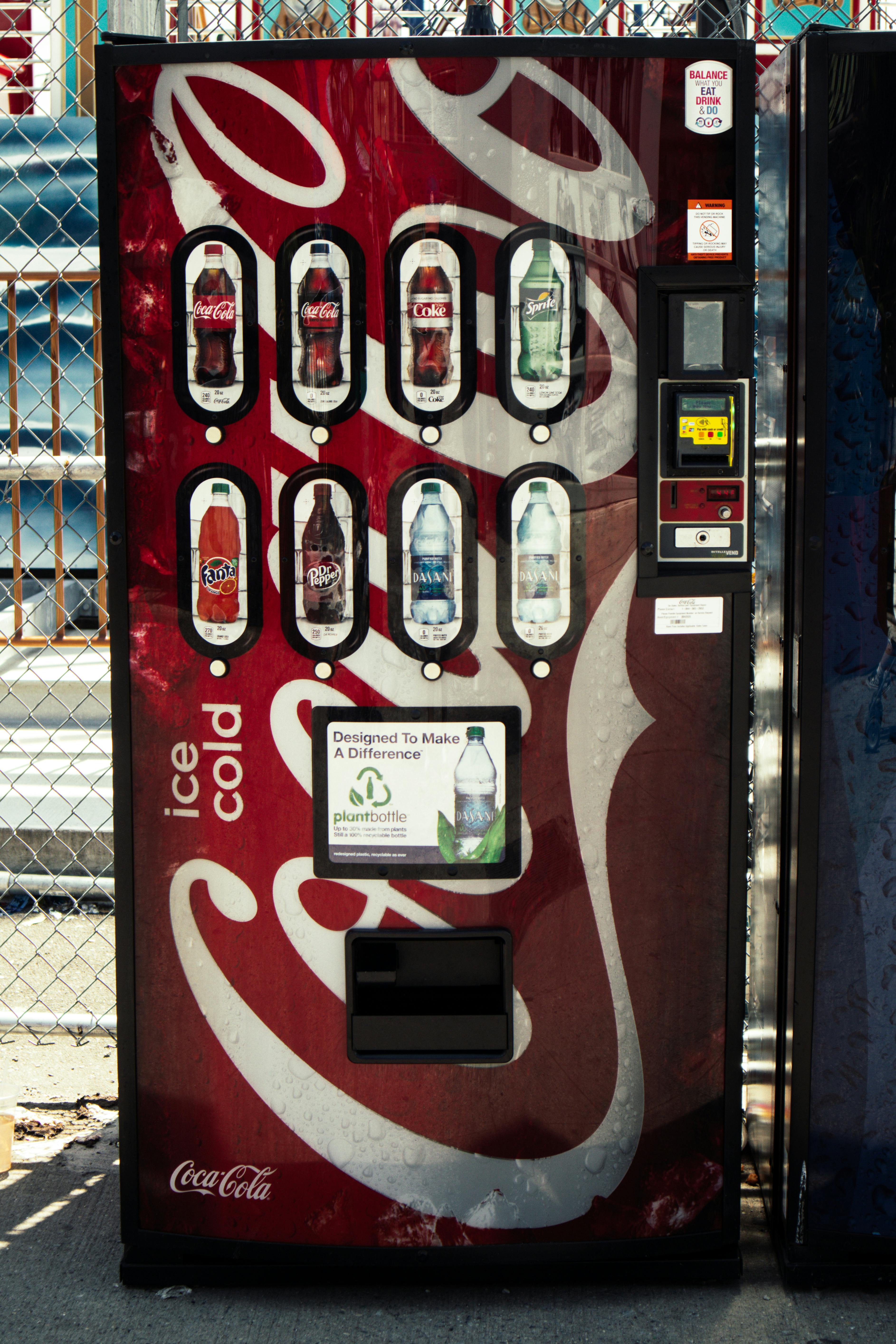無料 屋外に設置されたコカコーラの自動販売機では、さまざまな飲み物を販売しています。 写真素材