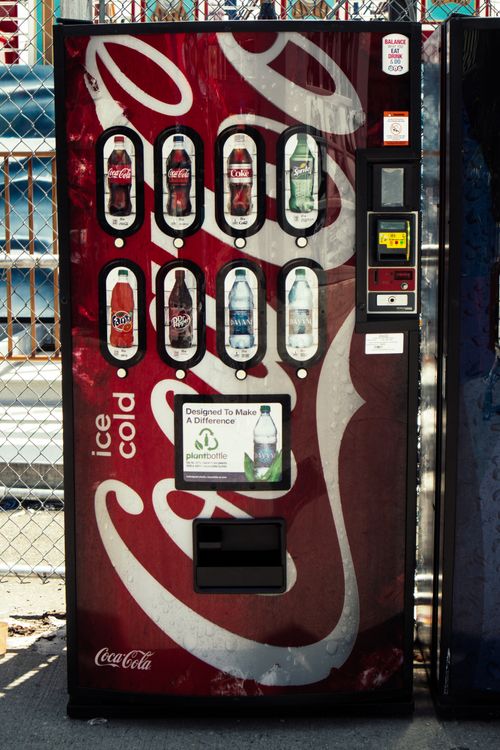 Free Coca-Cola vending machine located outdoors offering an assortment of beverages. Stock Photo