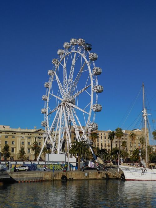 Free Scenic view of a Ferris wheel at Barcelona's waterfront against a clear blue sky. Stock Photo