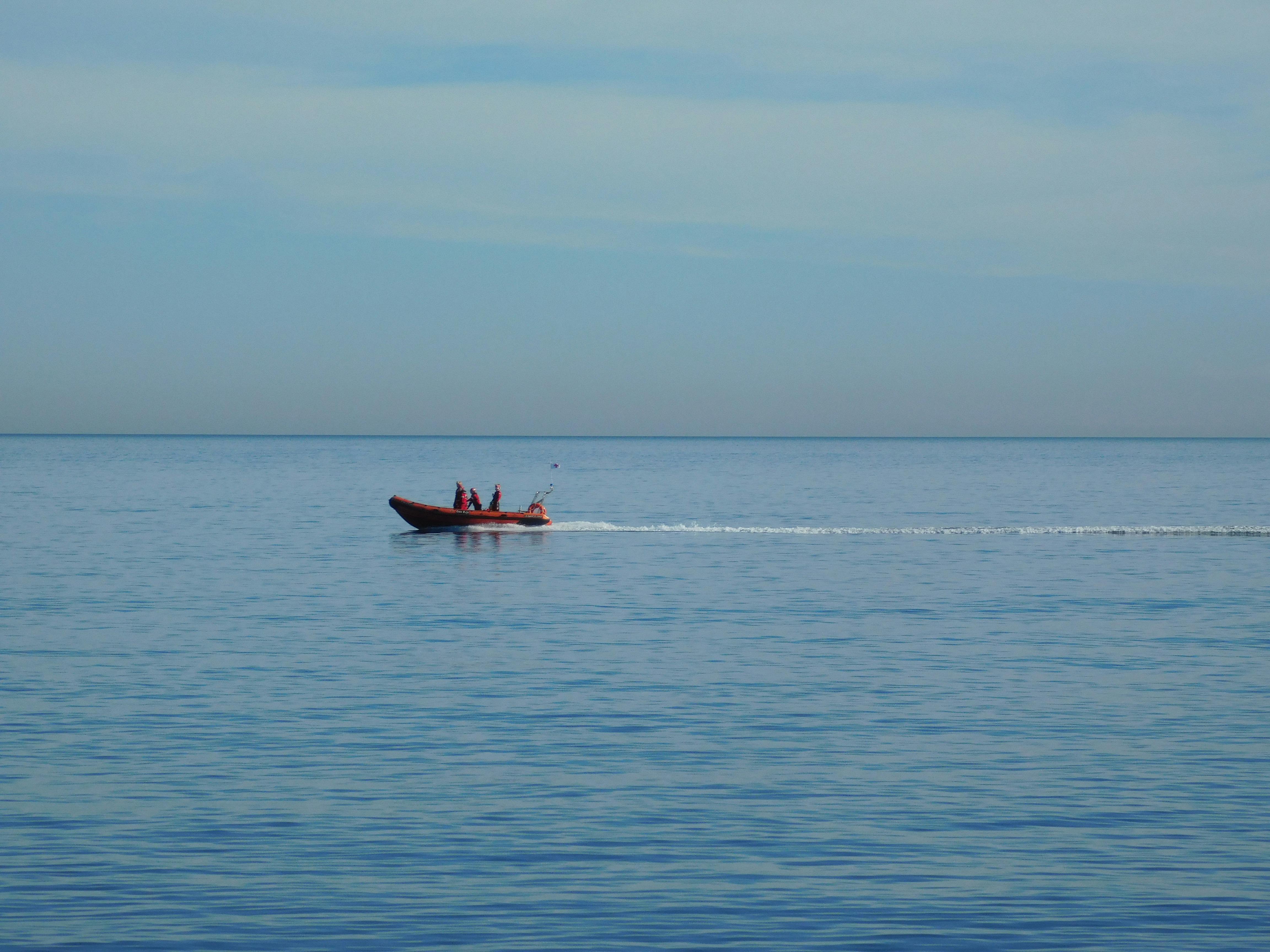 Free A speedboat with three people cruising the calm Mediterranean Sea near Barcelona. Stock Photo