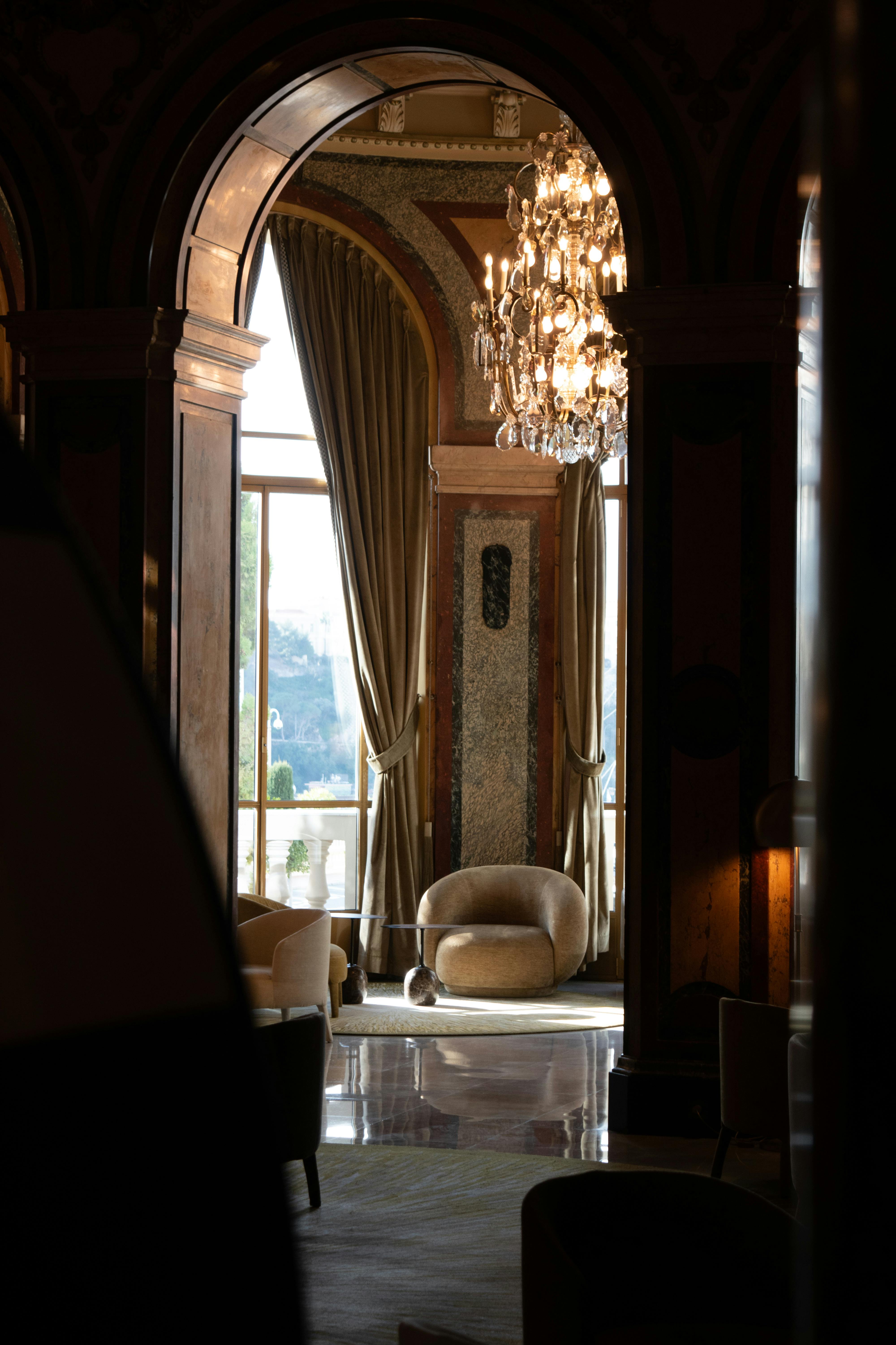 Gratis Lounge hotel yang elegan dengan lampu gantung, tirai berjumbai, dan tempat duduk empuk di Nice, Prancis. Foto Stok