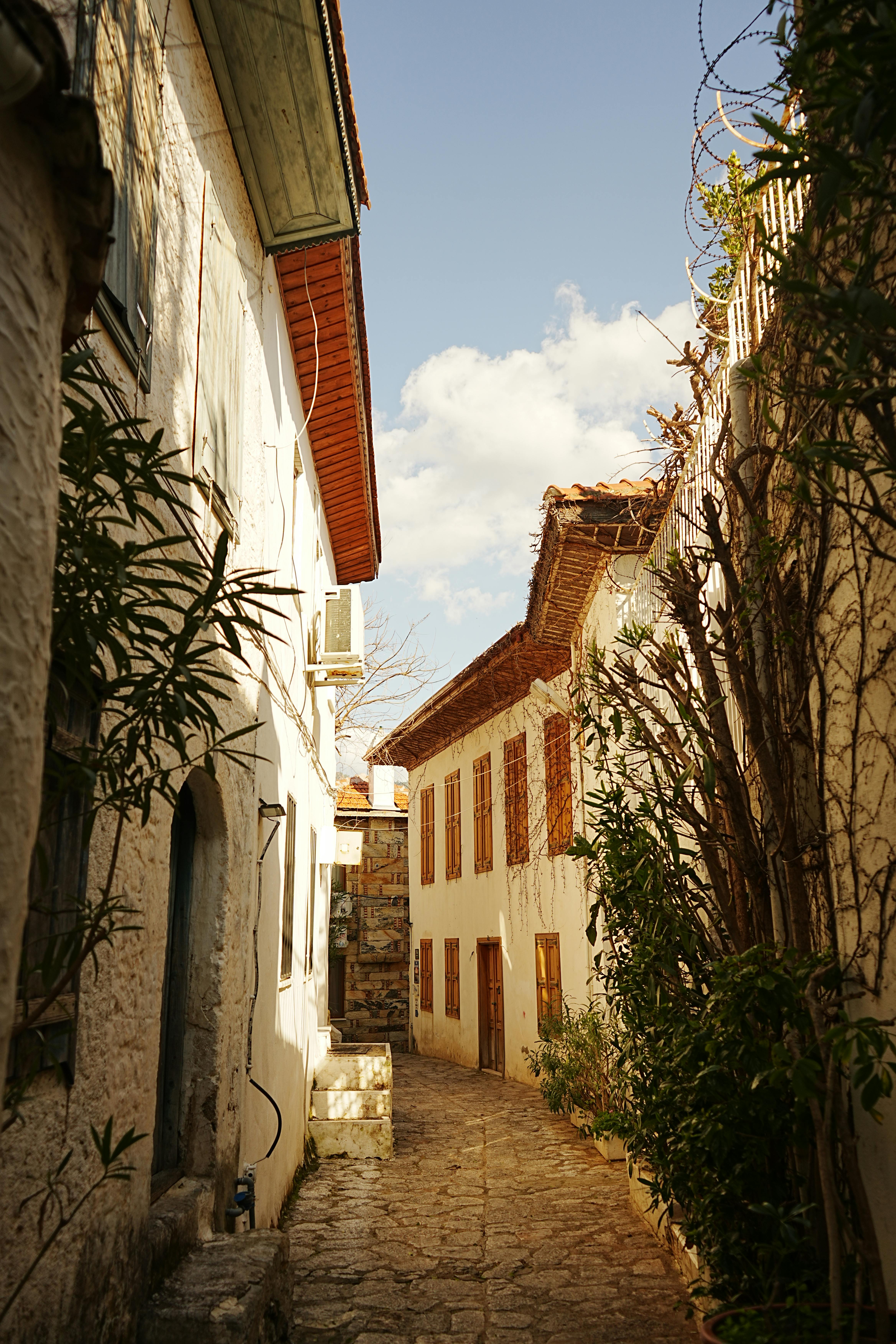 бесплатная Залитый солнцем узкий переулок с традиционной архитектурой в Мармарисе, Мугле, Турции. Стоковое фото