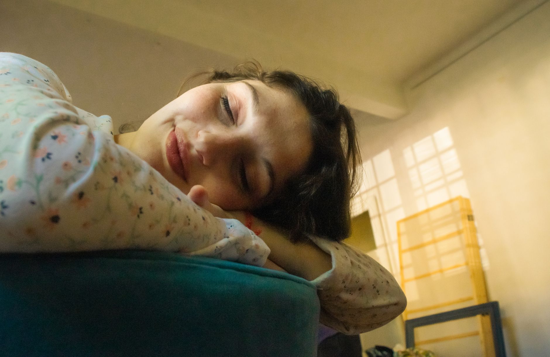 A serene woman peacefully resting indoors, captured in soft natural light for a calm, relaxing atmosphere.