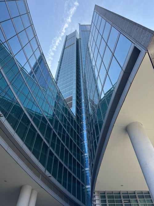 Free Upward view of a modern skyscraper with blue glass facade in Milan, Italy. Stock Photo