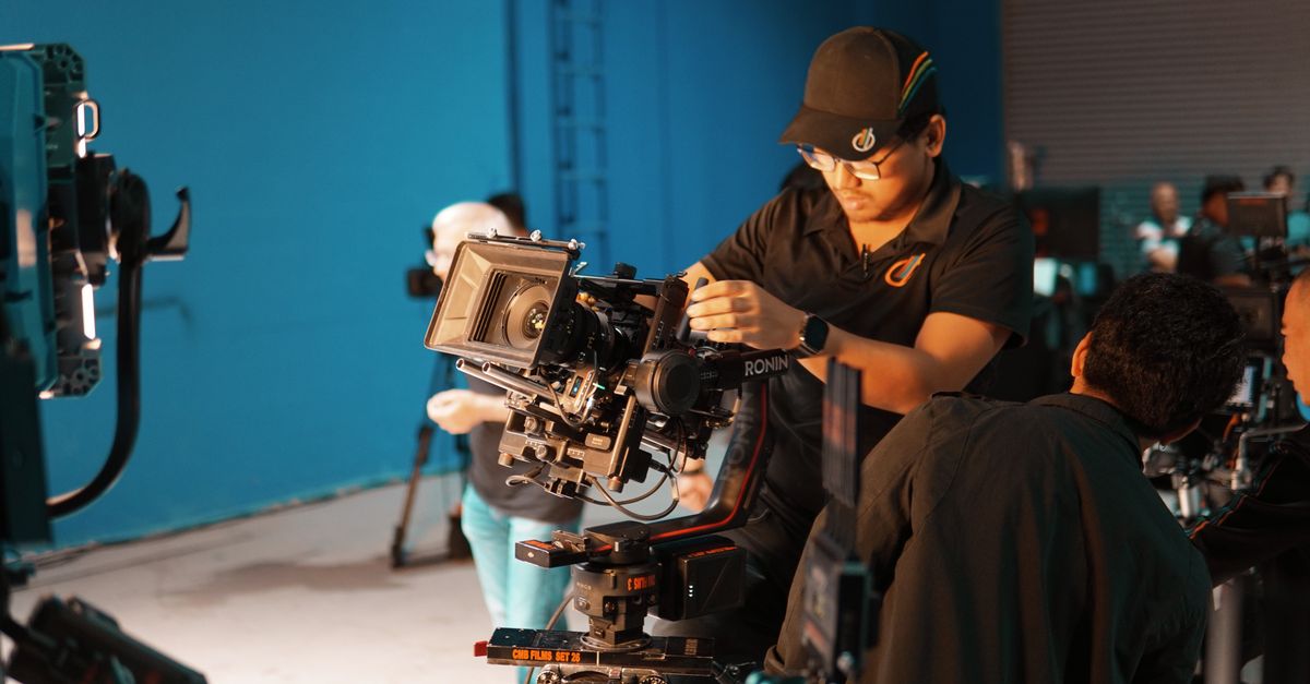 A film crew setting up professional camera equipment in a studio