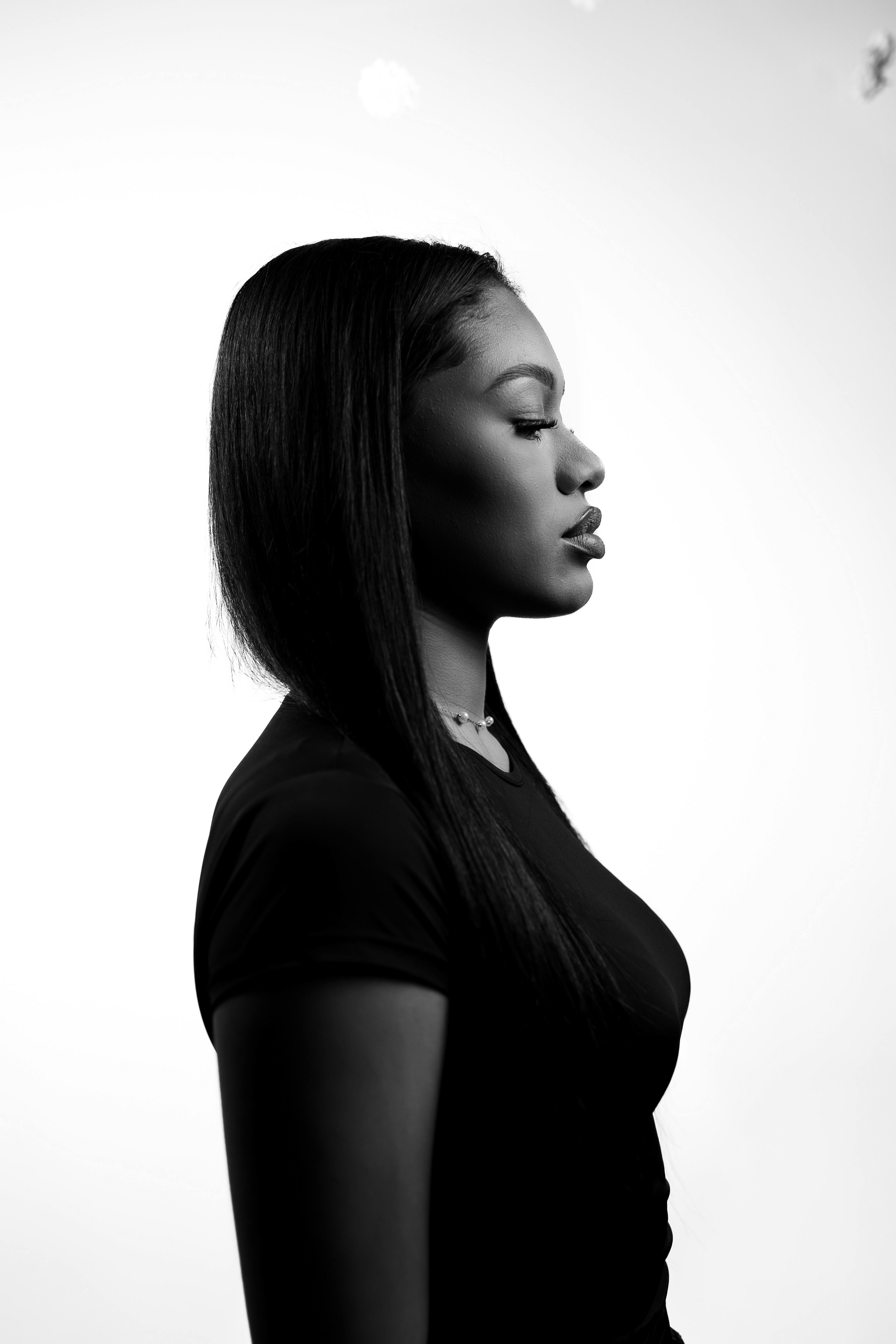 Artistic black and white portrait of a woman, showcasing side profile and elegance.