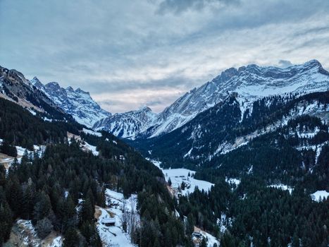 Stunning aerial view of snow-laden peaks in the Swiss Alps, capturing winter's beauty.