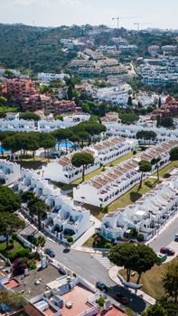 Aerial photo showcasing white villas in scenic Marbella, reflecting unique Andalusian architecture.